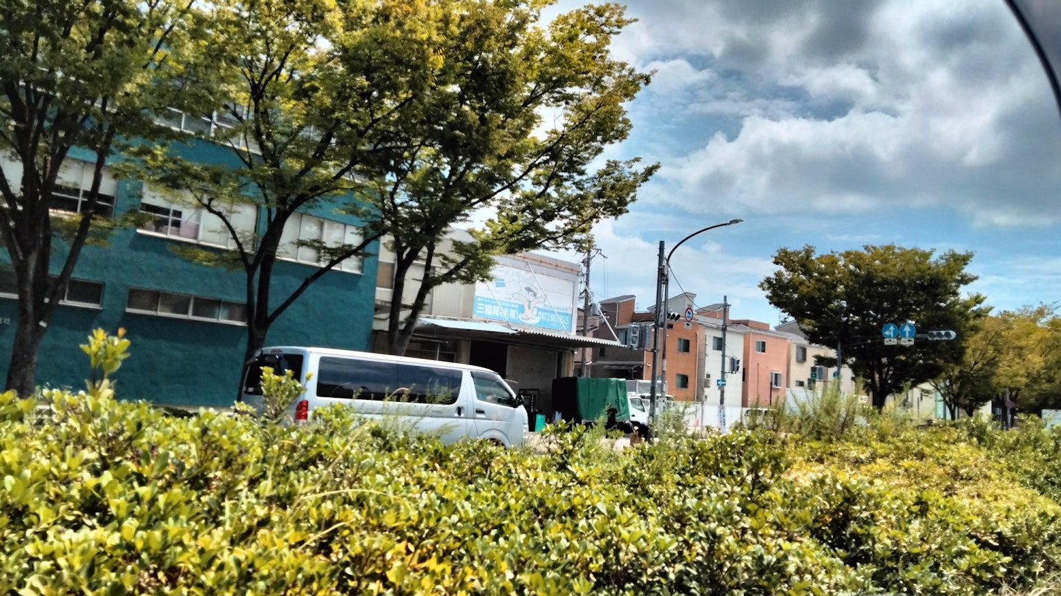 城市景观，有蓝色建筑和白色面包车