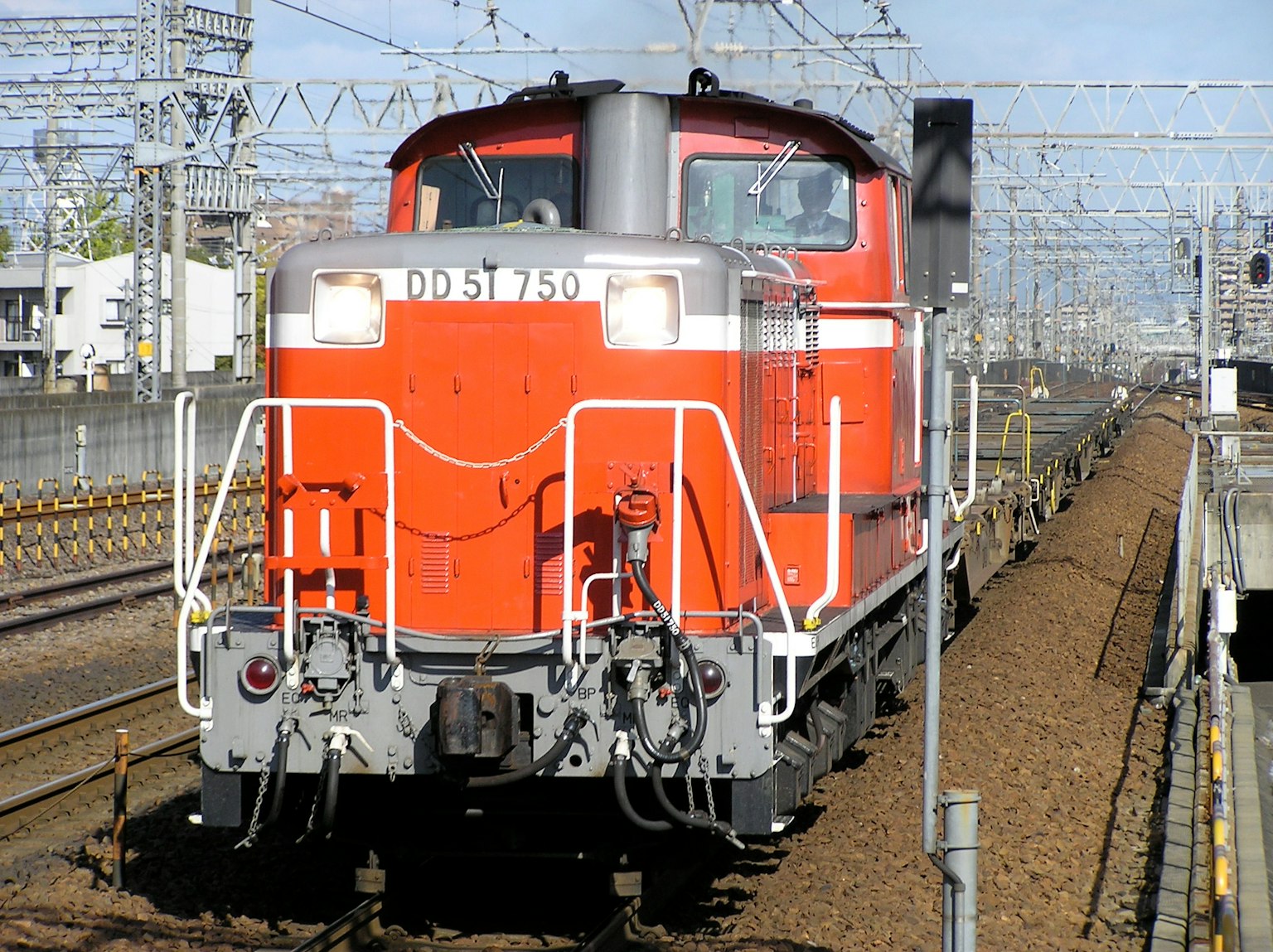 赤いディーゼル機関車が線路を走行中