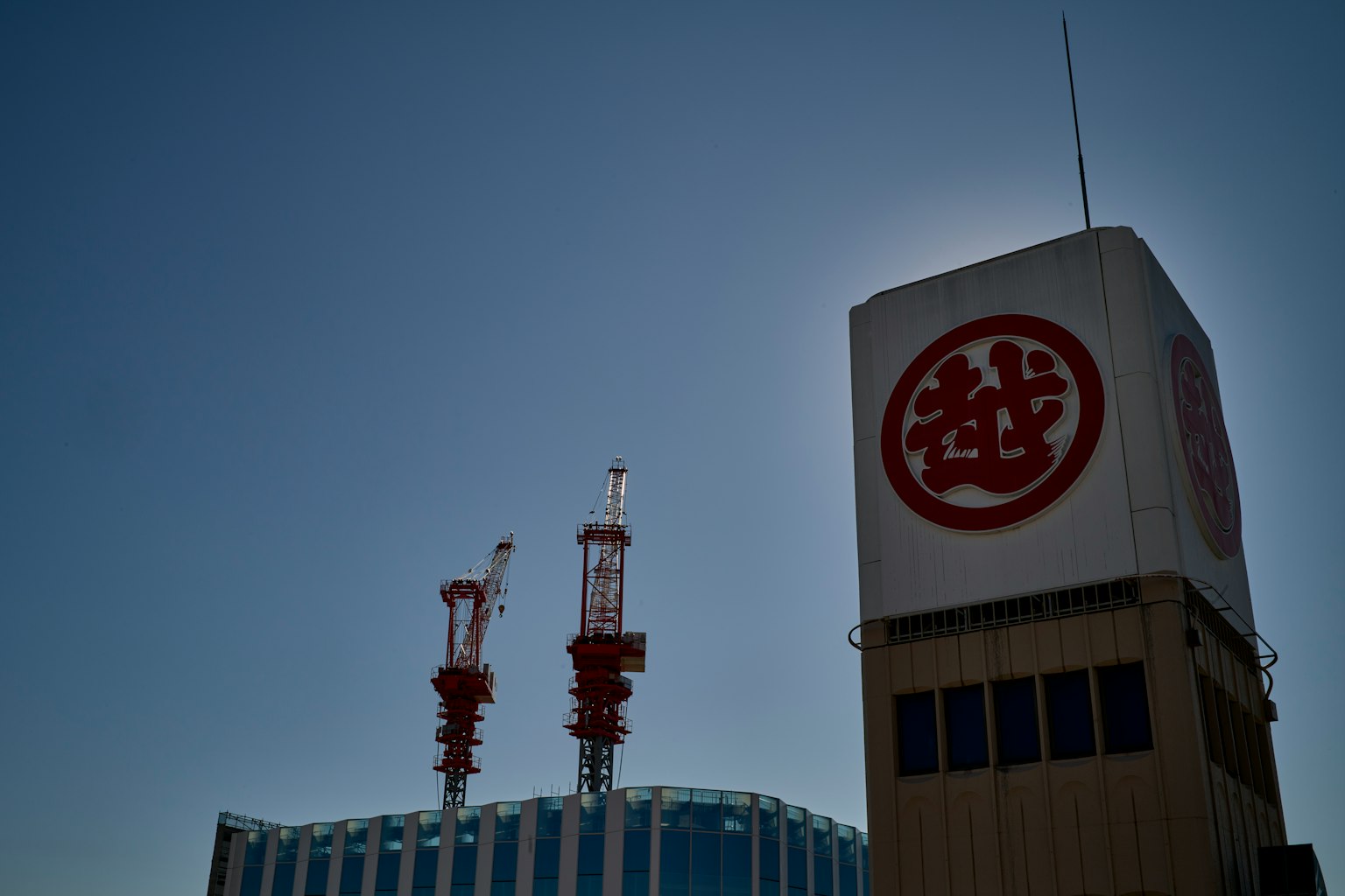 Grande edificio sotto un cielo blu con torre con logo rosso