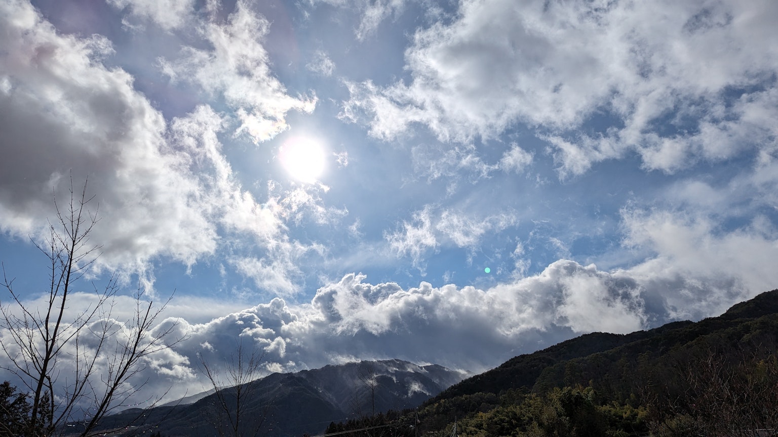 Berglandschaft mit hellem Sonnenlicht und verstreuten Wolken