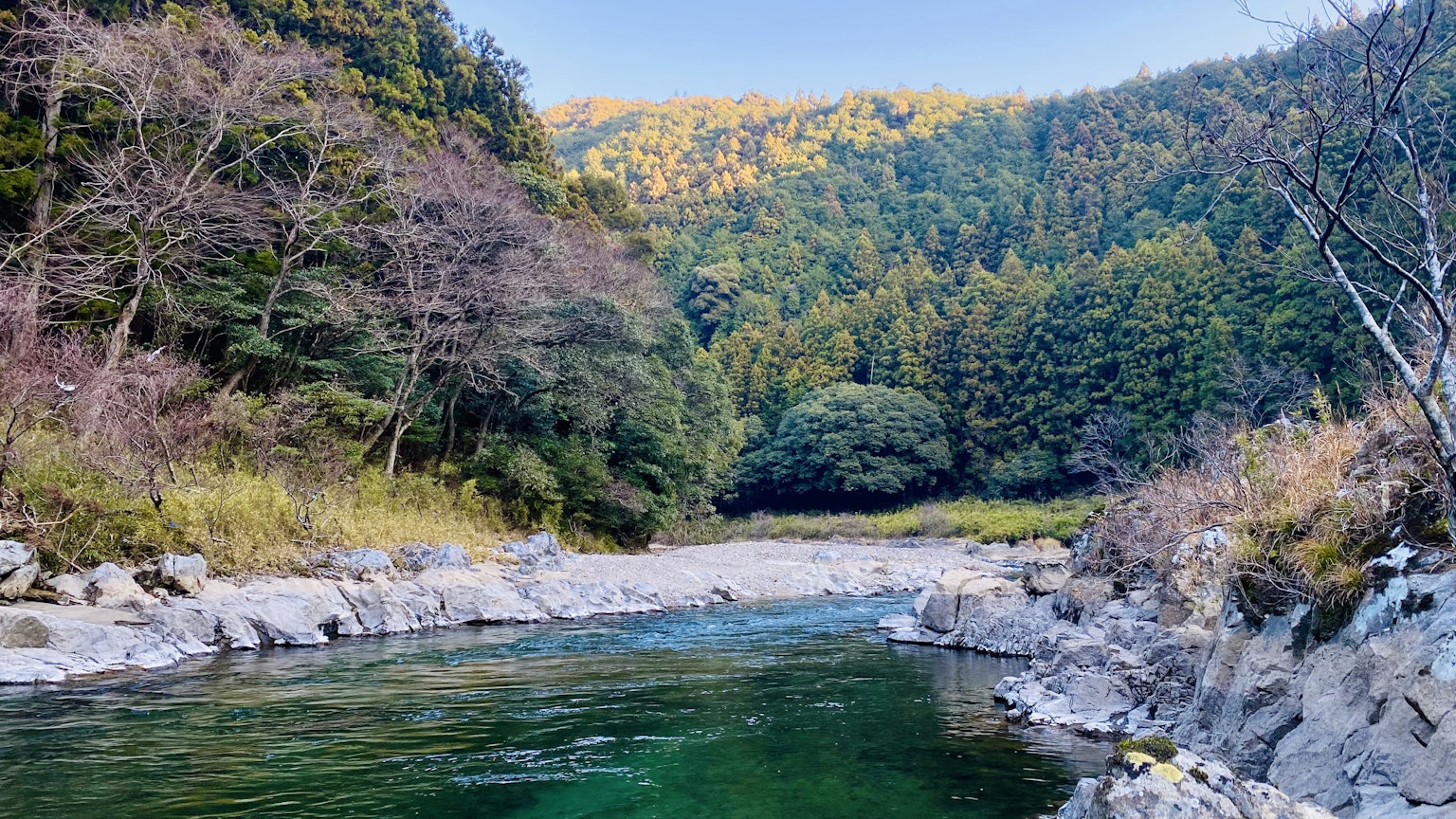 Pemandangan indah sungai dengan air hijau dan pegunungan di sekitarnya