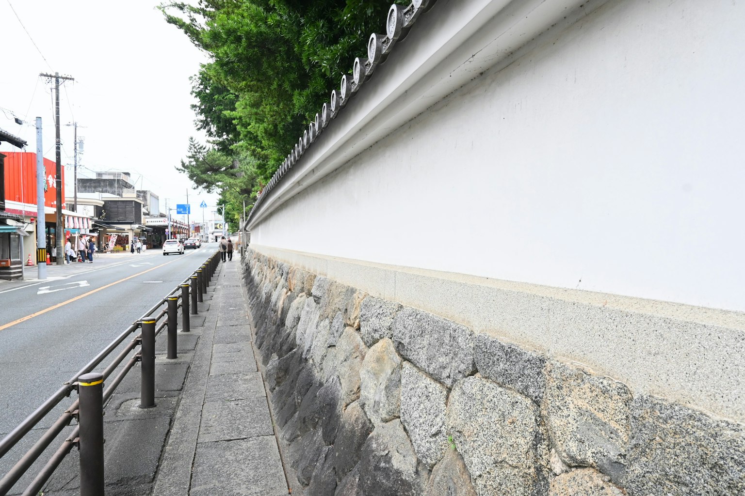ทิวทัศน์ถนนเงียบสงบที่มีกำแพงหินและรั้วสีขาว