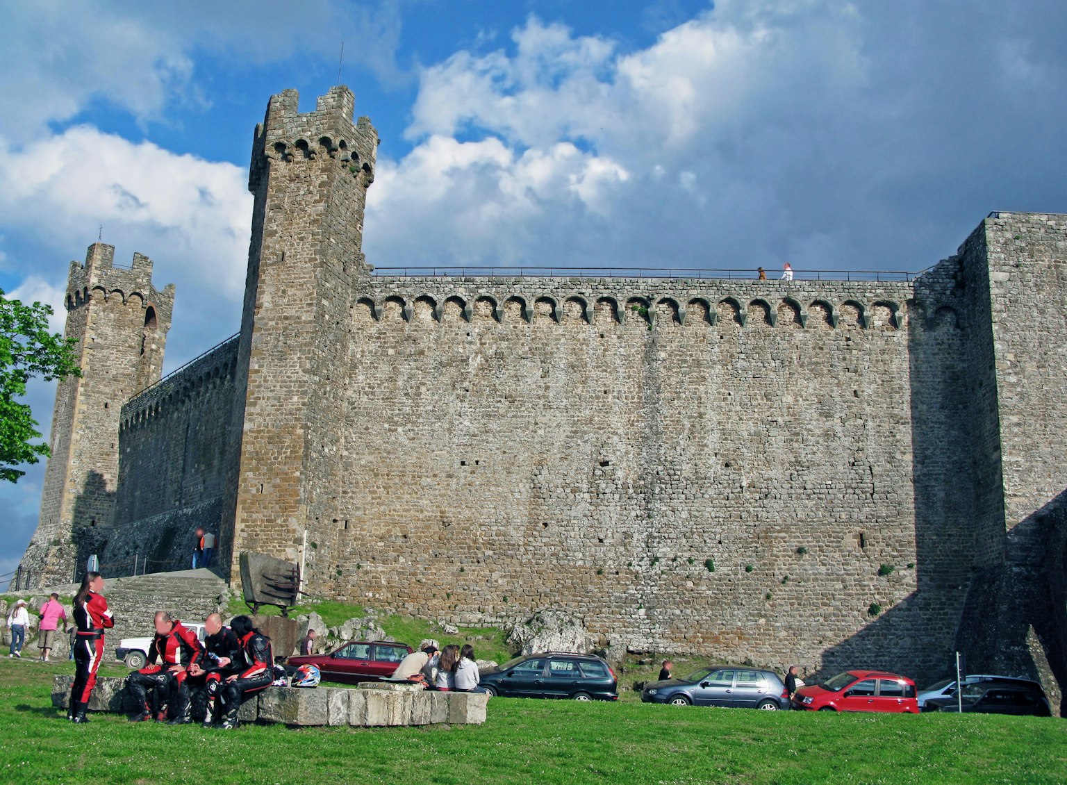 Gathering of people in front of medieval castle walls and towers