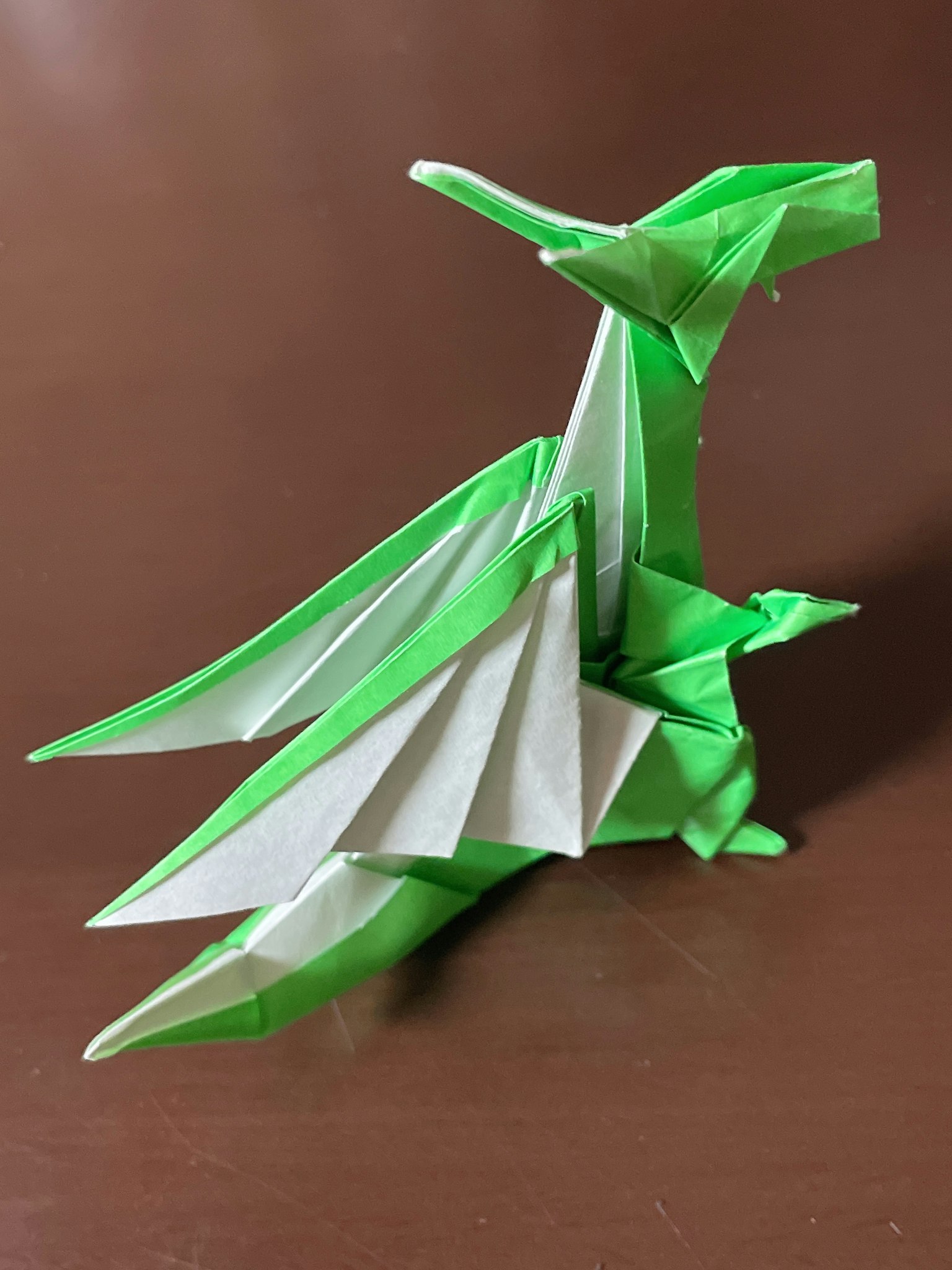 Drago in origami verde e bianco in piedi