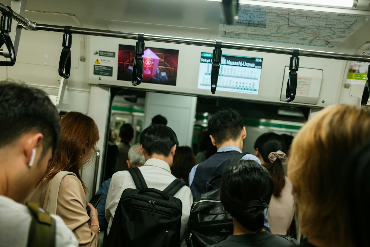 Interior kereta bawah tanah yang ramai dengan penumpang menghadap ke depan