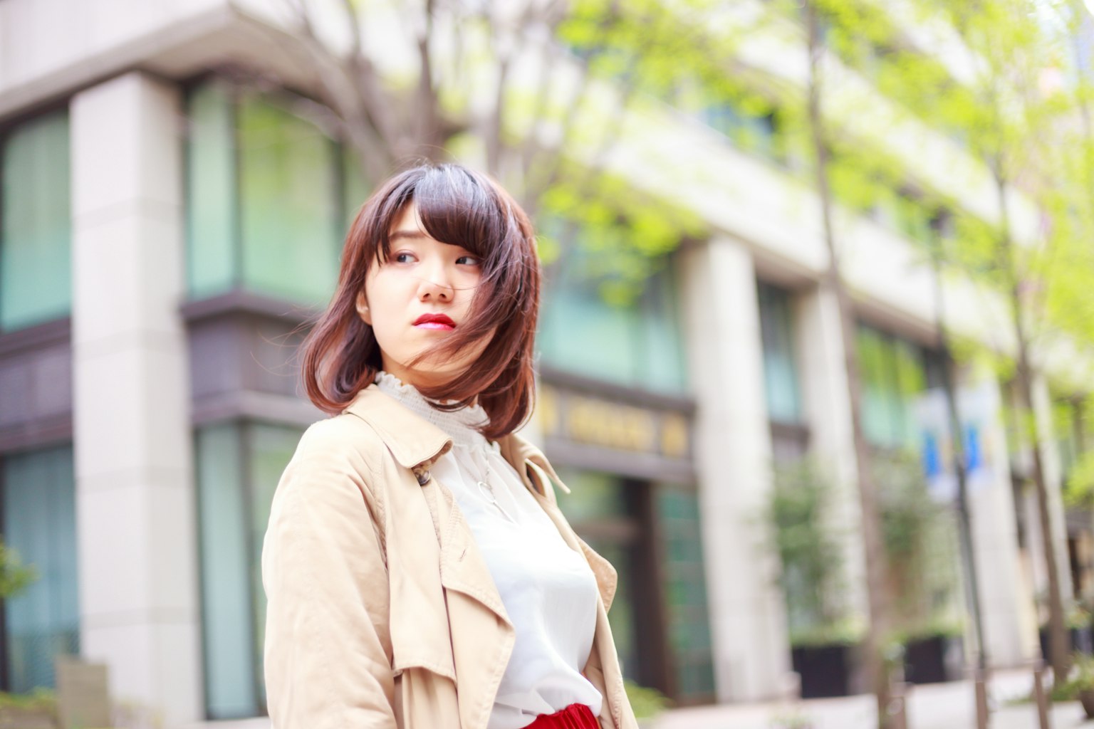 年輕女性在城市街道上回頭背景是現代建築和綠色樹木