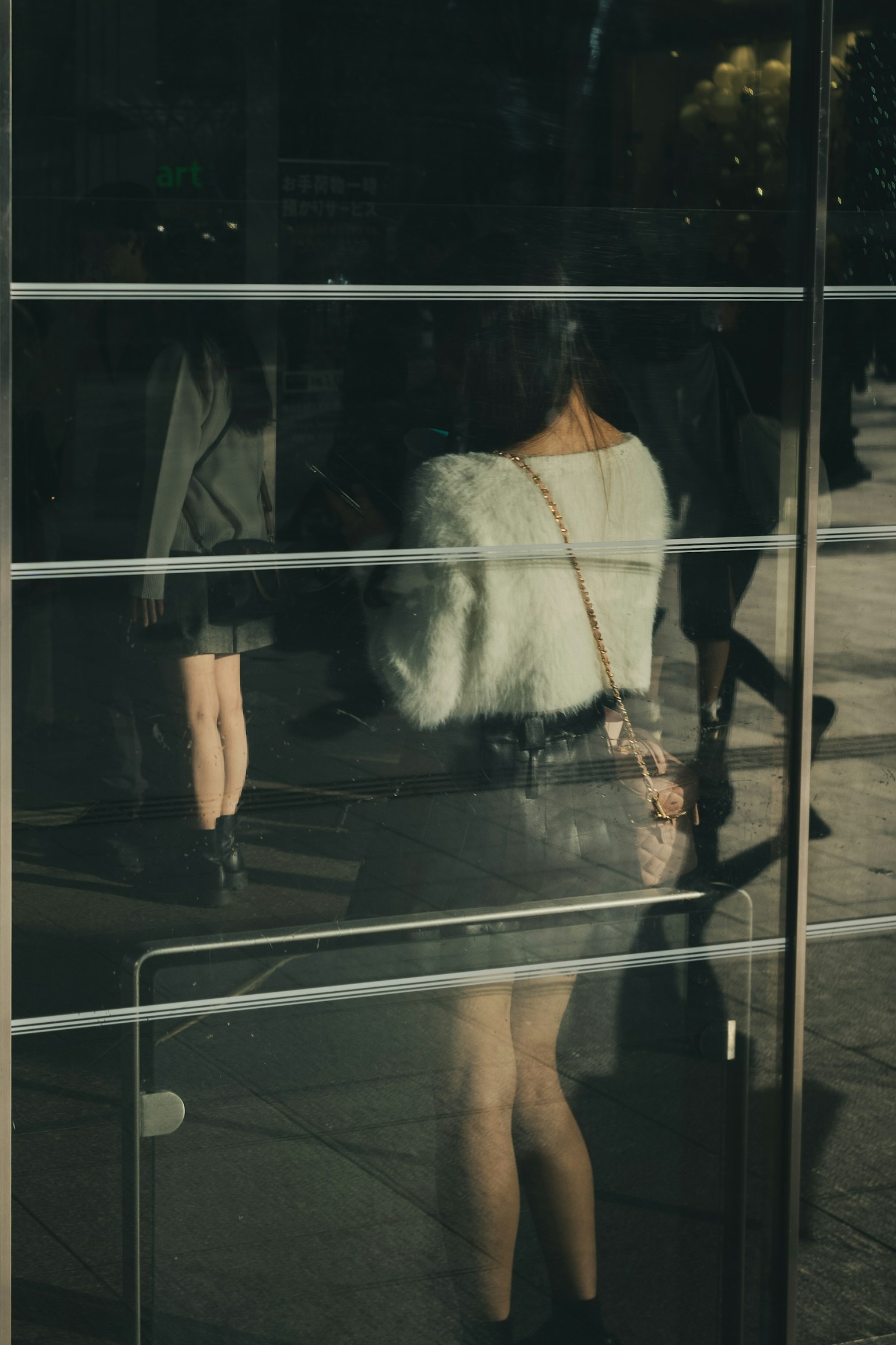 Reflection of a woman in a glass with surrounding people