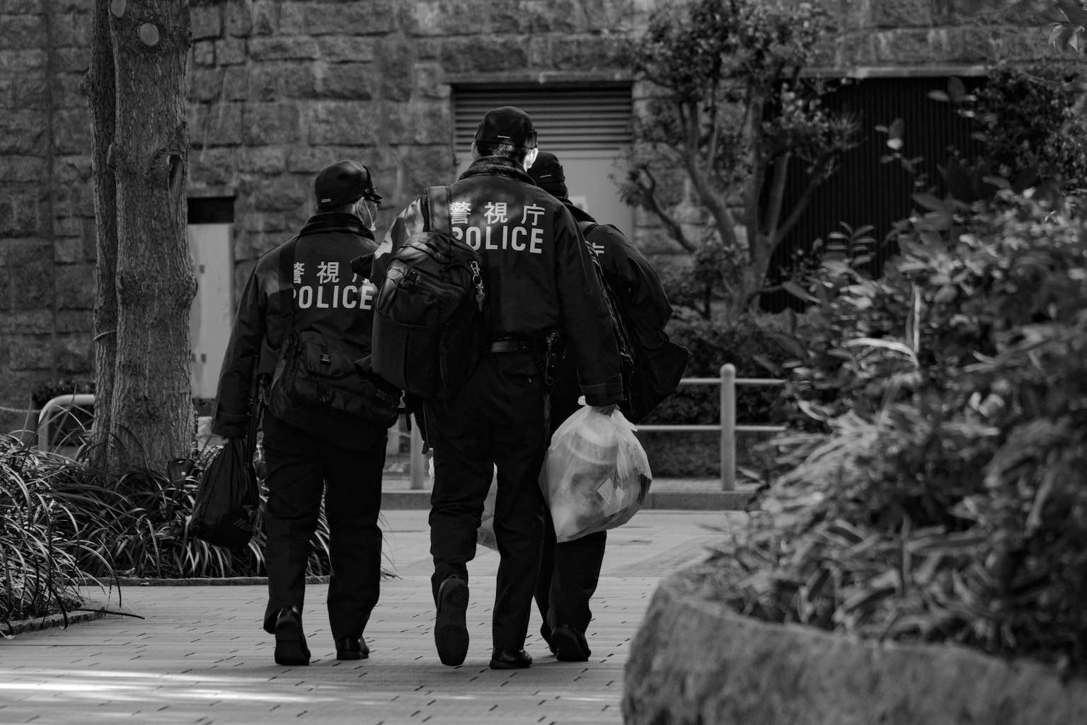 黑白圖像，警察在公園裡走