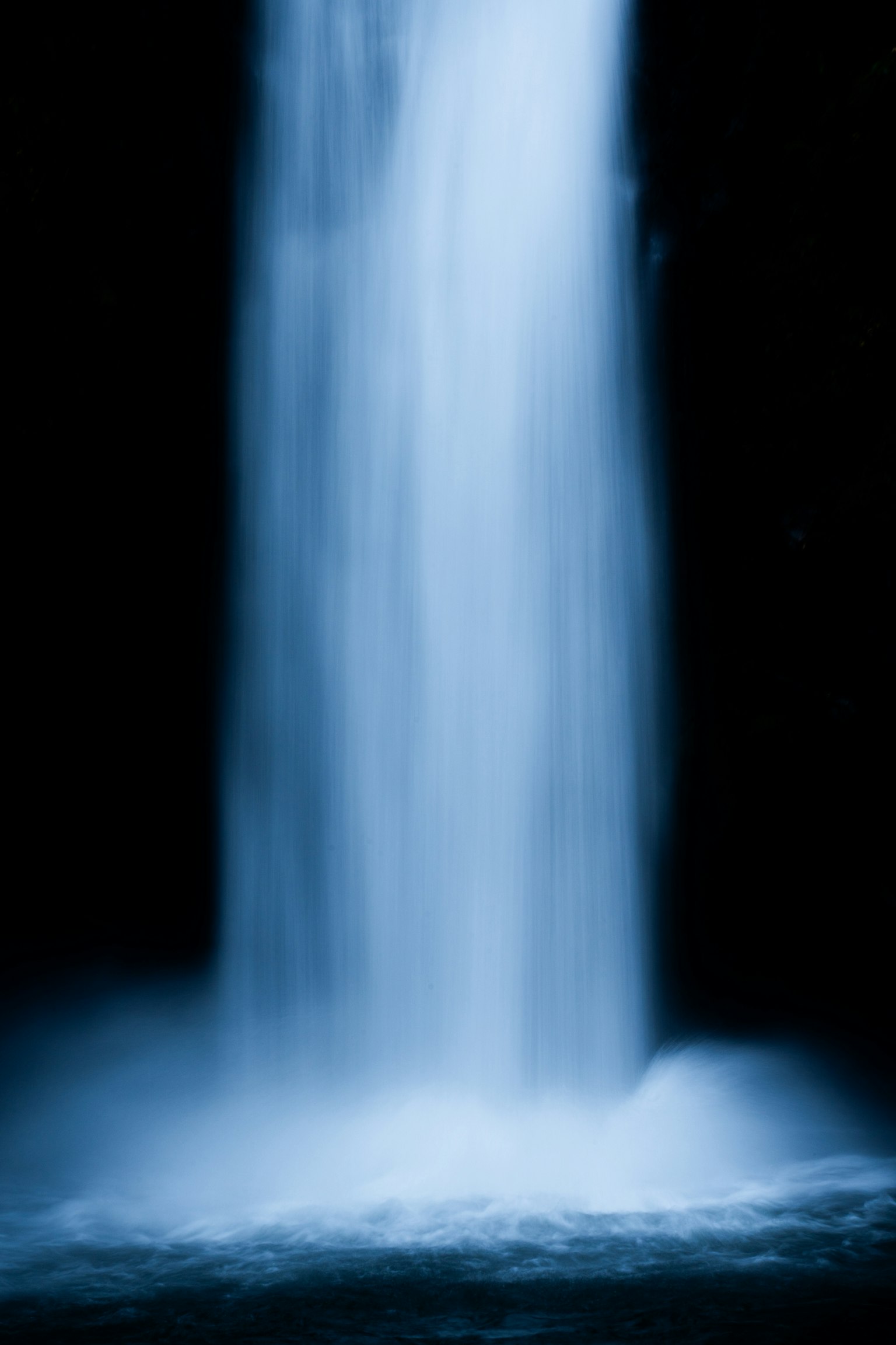 Une belle image d'une cascade bleue s'écoulant sur un fond sombre