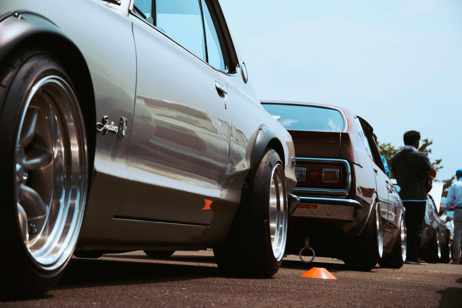 Cảnh sự kiện ô tô với xe tùy chỉnh màu bạc bên cạnh xe cổ điển