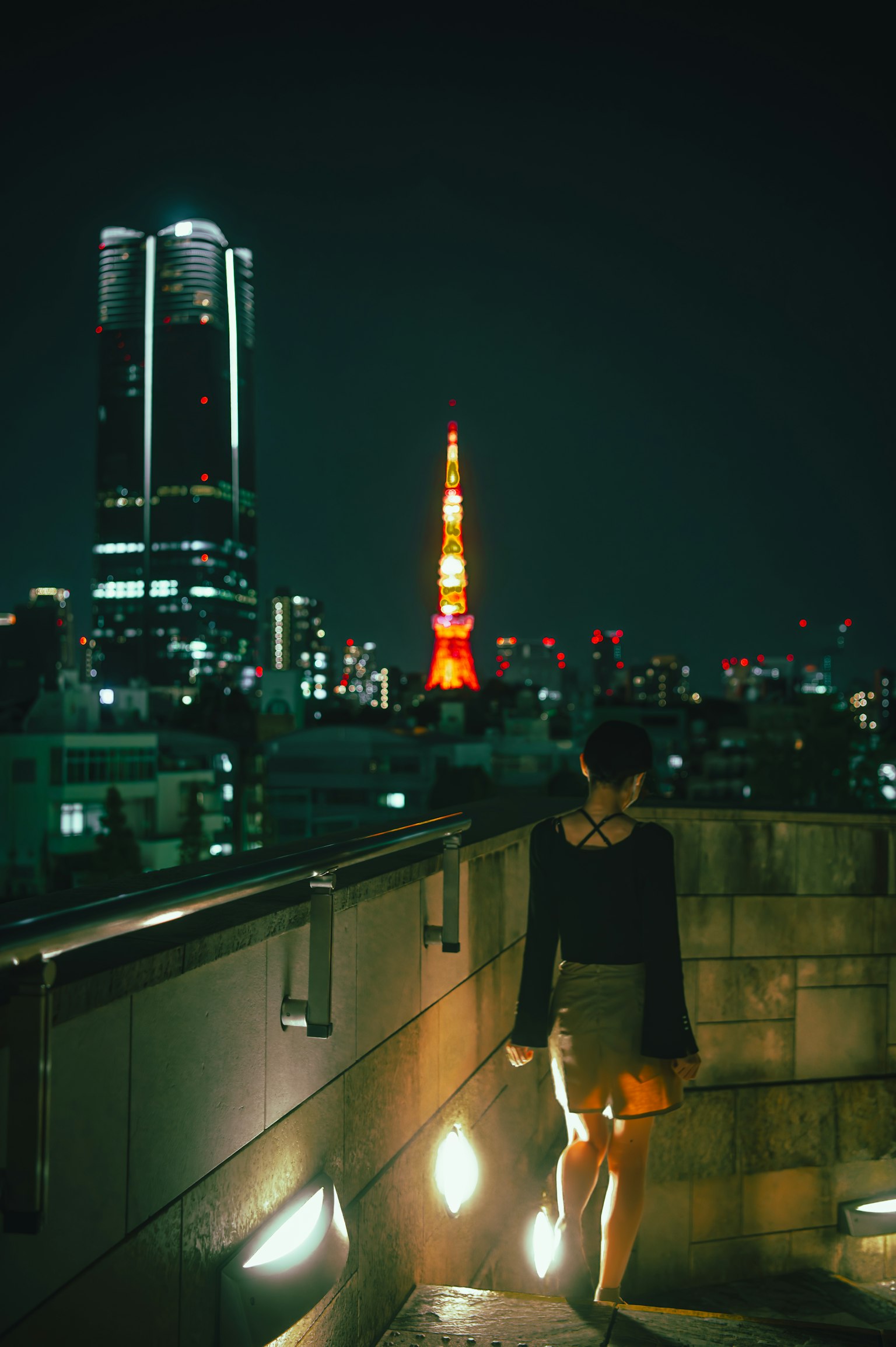 夜の東京の街を歩く女性 東京タワーが背景にある