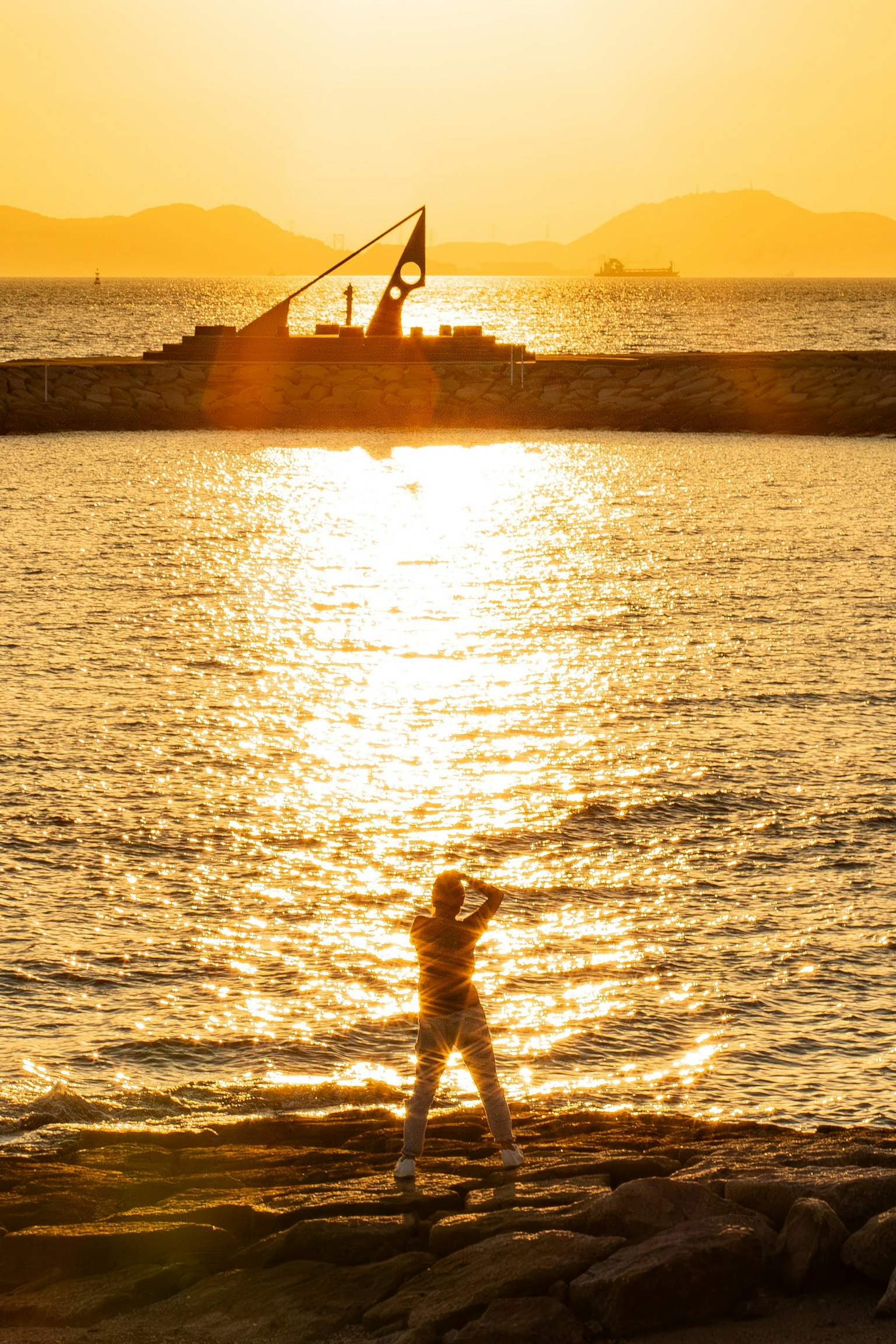 Personne posant sur le rivage au coucher du soleil