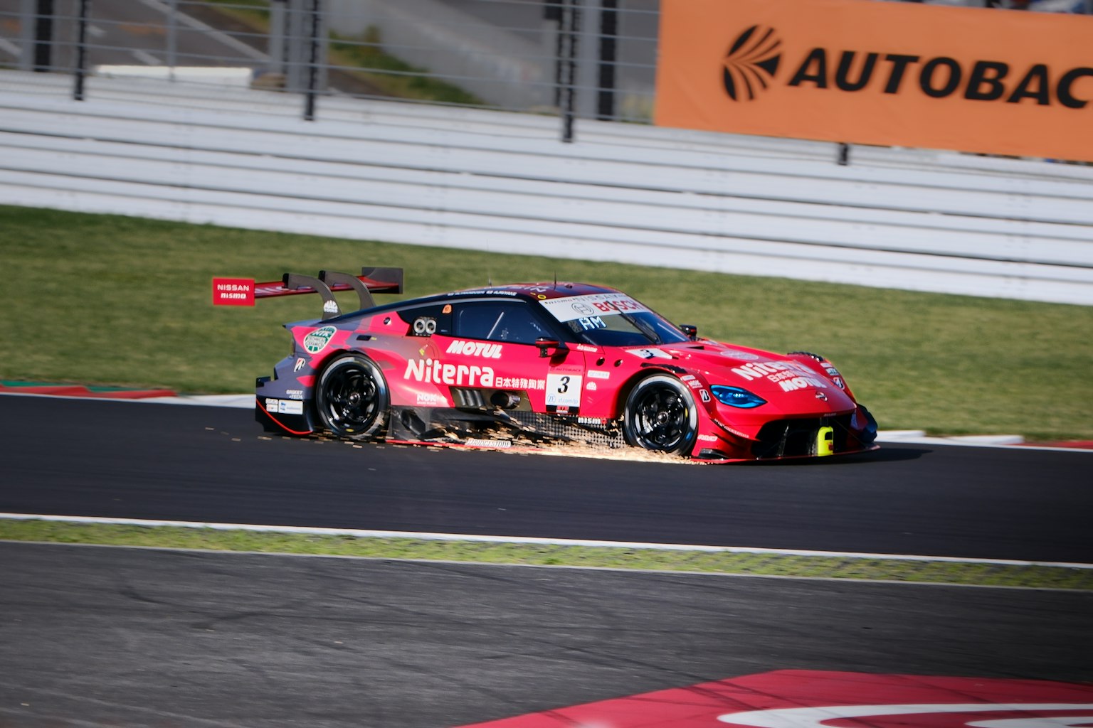 Voiture de course rouge dérapant dans un virage sur la piste
