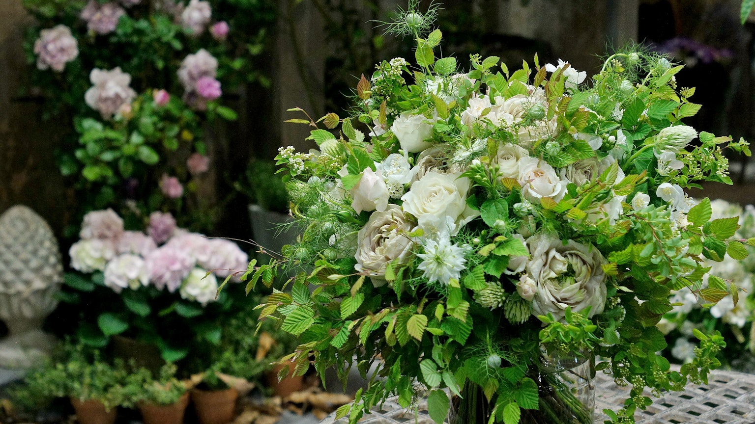 Hermoso ramo de flores blancas y verdes con flores de fondo