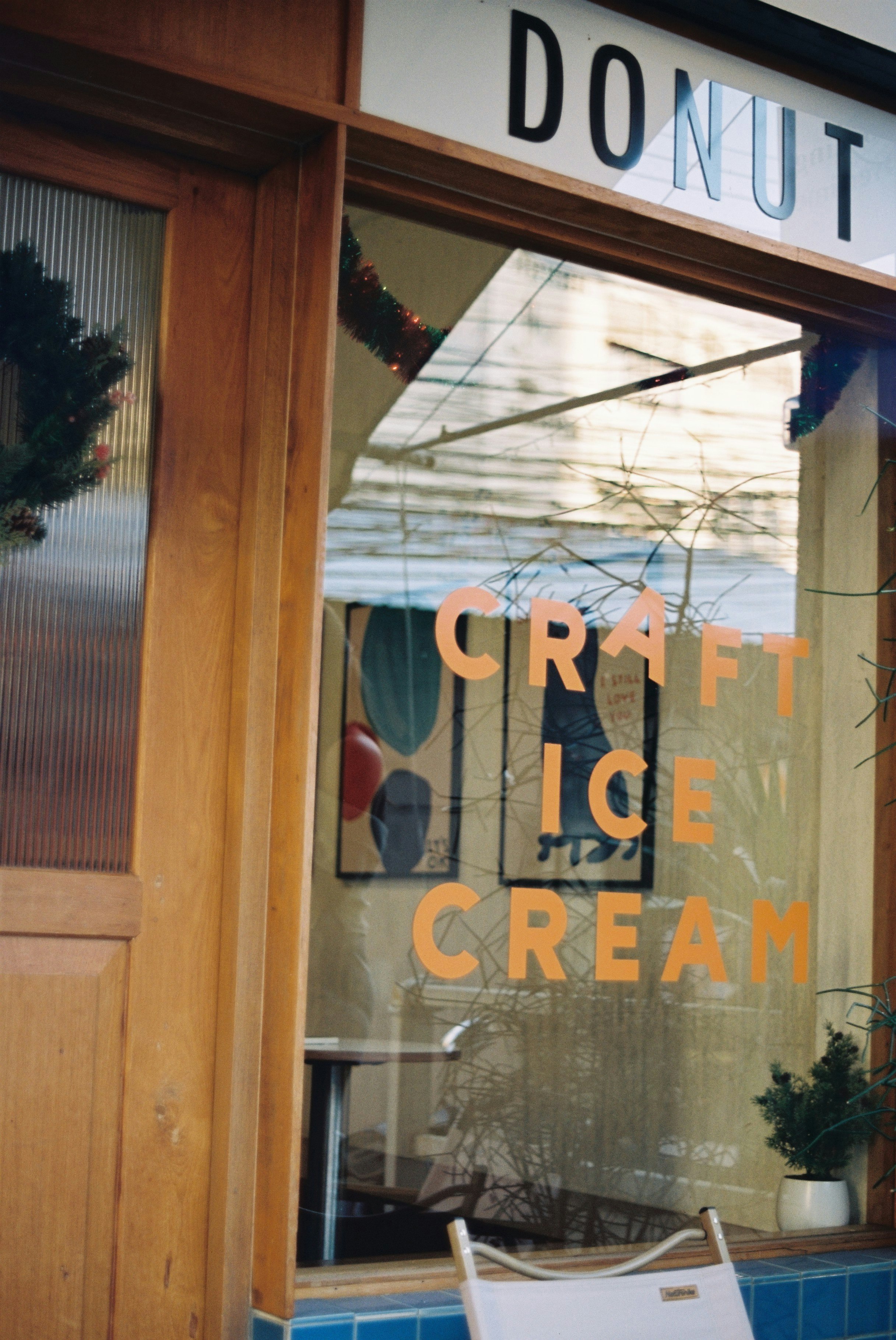 「DONUT」看板のある窓越しに見えるクラフトアイスクリーム店の外観