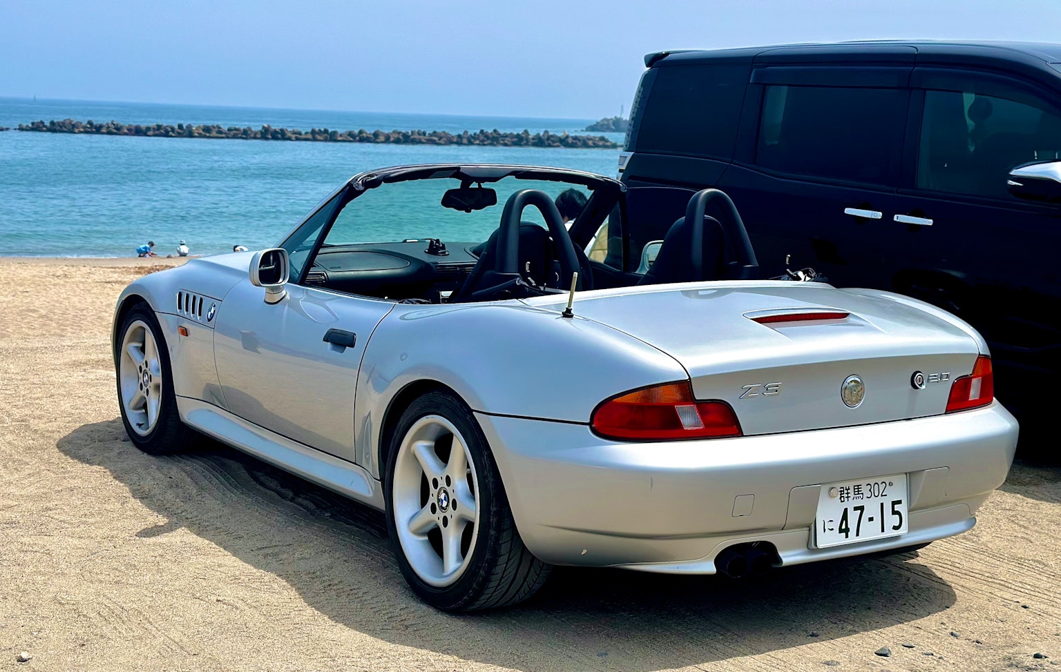 Cabriolet plateado estacionado junto a la playa