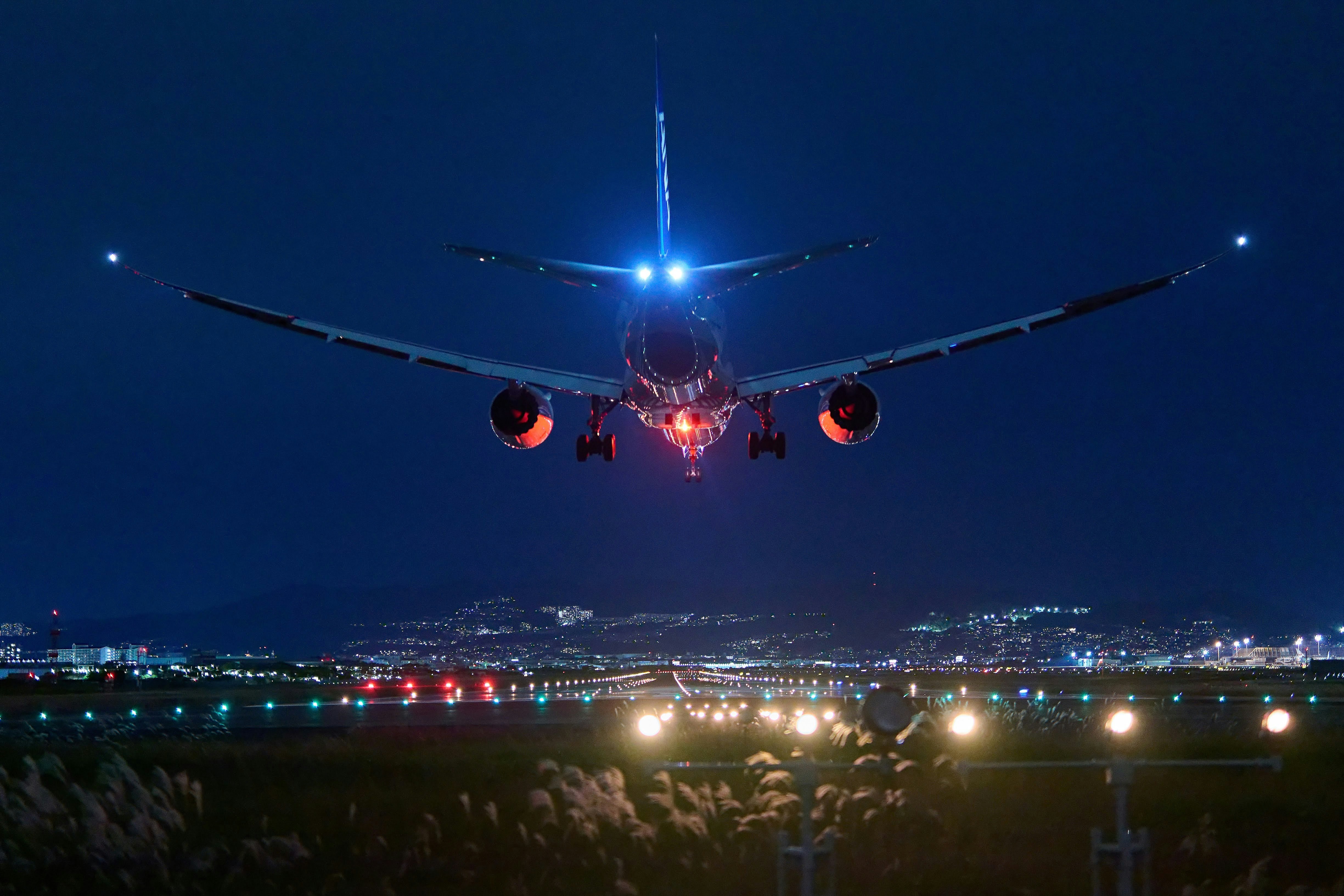 伊丹空港の夜空を飛ぶ旅客機の機影