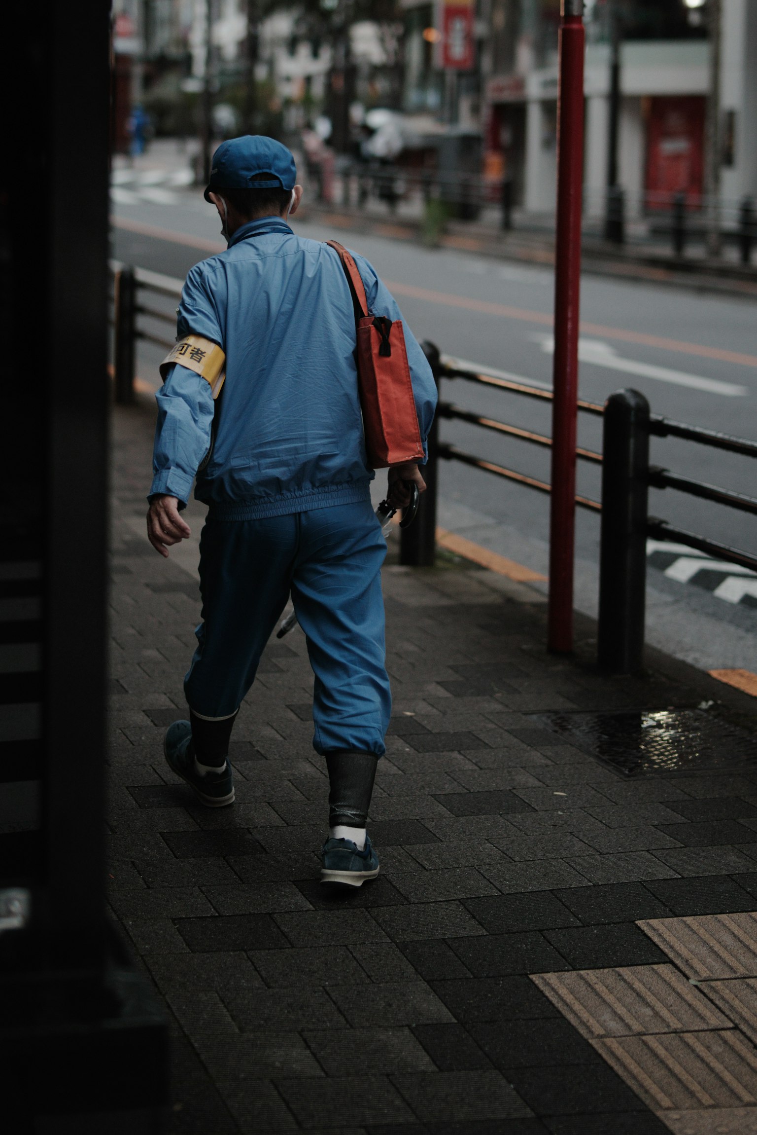 Un lavoratore in uniforme blu che cammina per strada