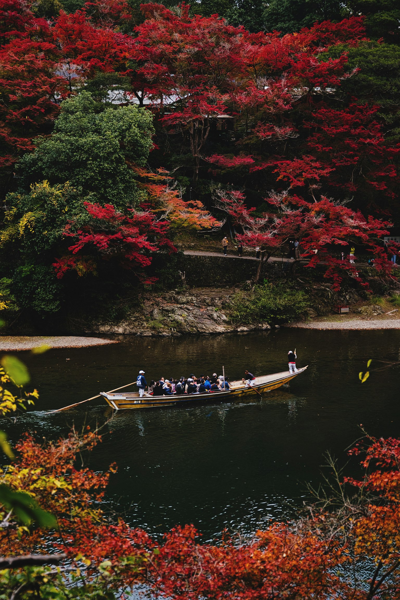 Un barco navegando por un río sereno rodeado de vibrante follaje de otoño