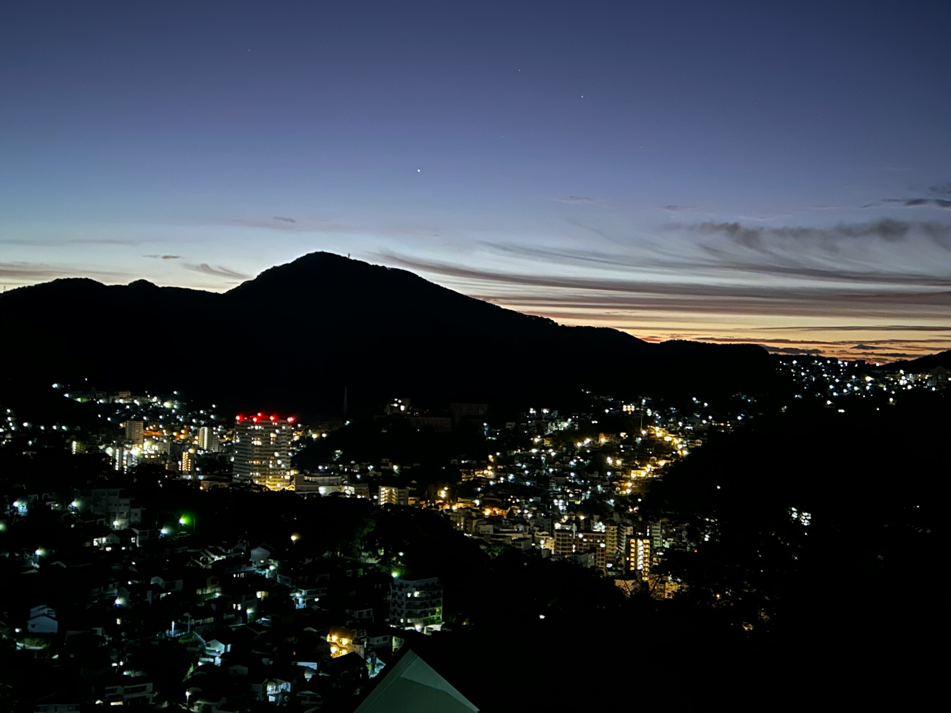 winter night cityscape over the sea with mountains