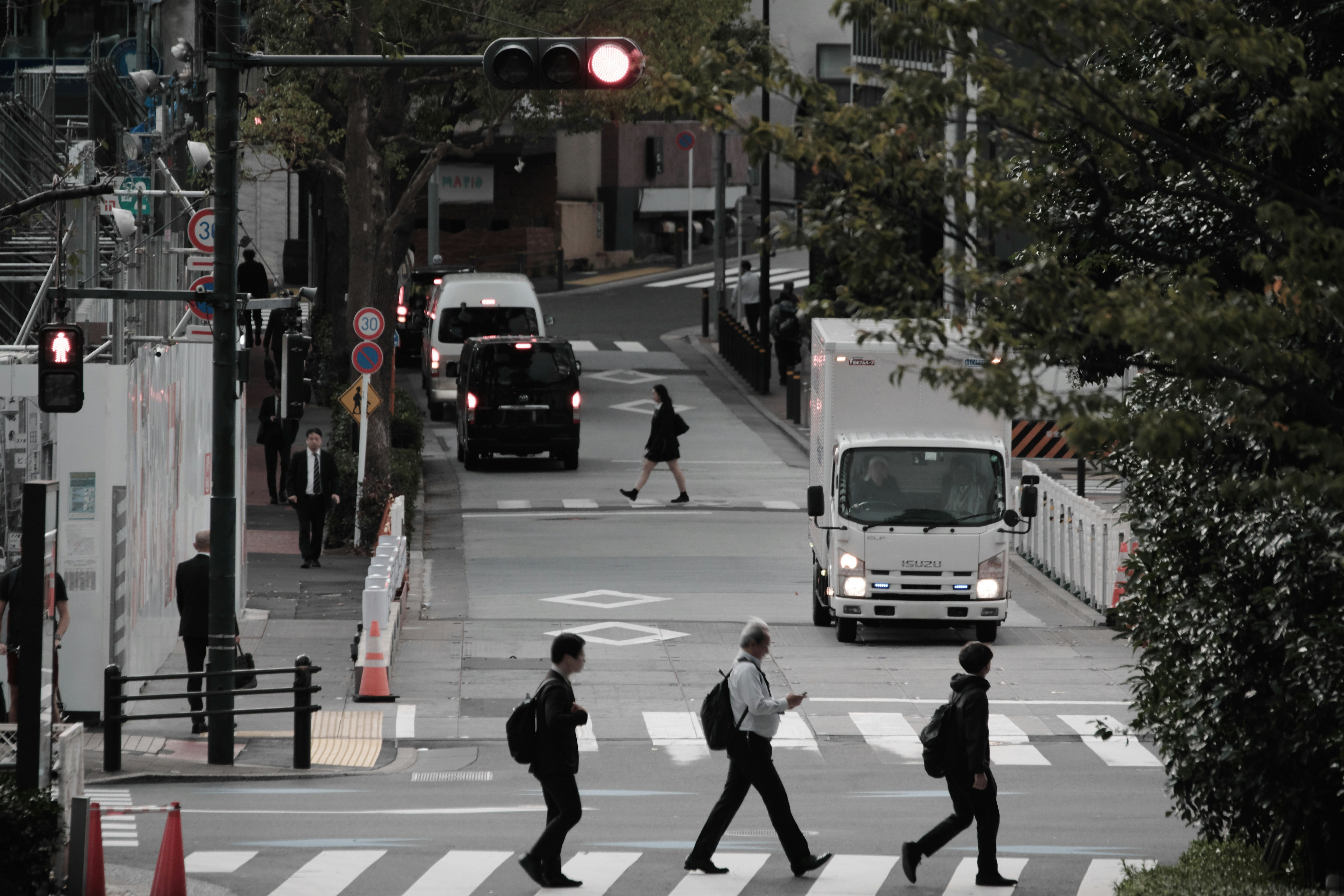 横断歩道を歩く人々がいる都市の街並み