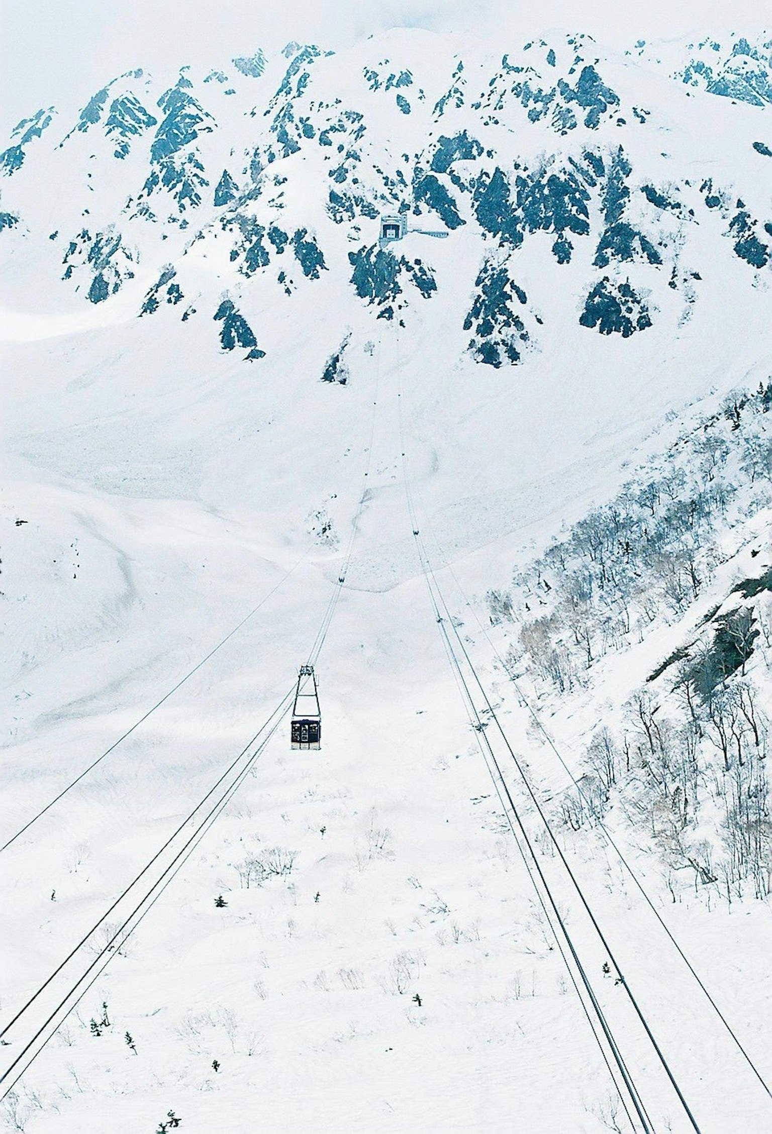 Paesaggio montano innevato con una funivia