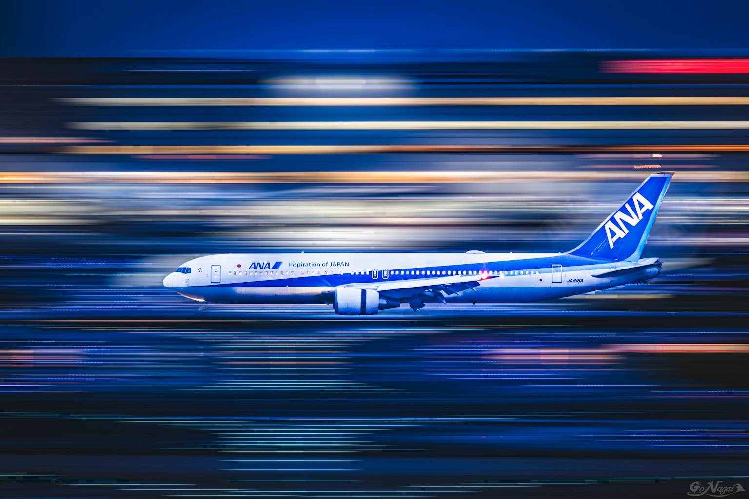 ANA-Flugzeug fliegt durch eine verschwommene Nachtszene