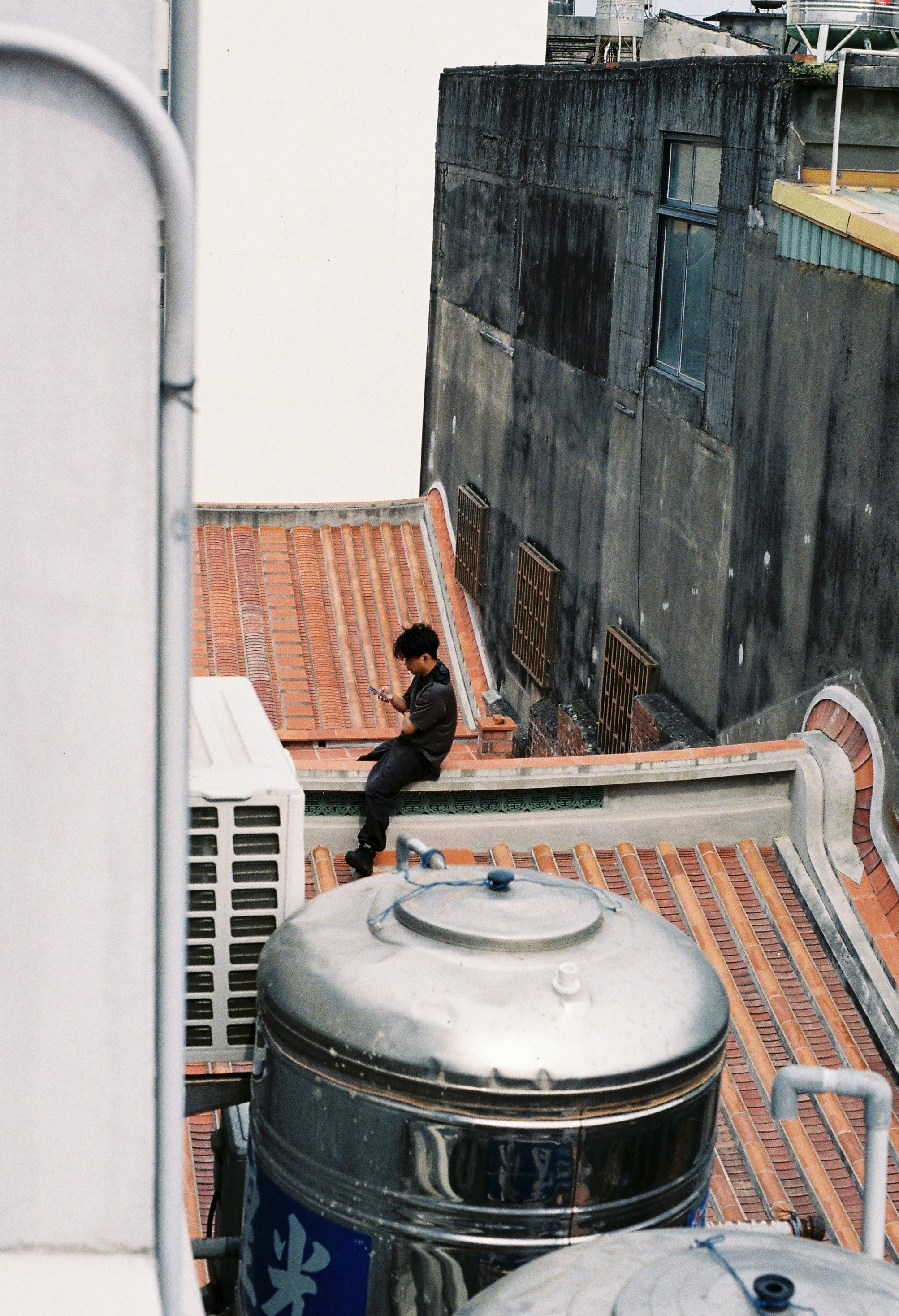 rooftop water heater and pipes on a brick-paved service area