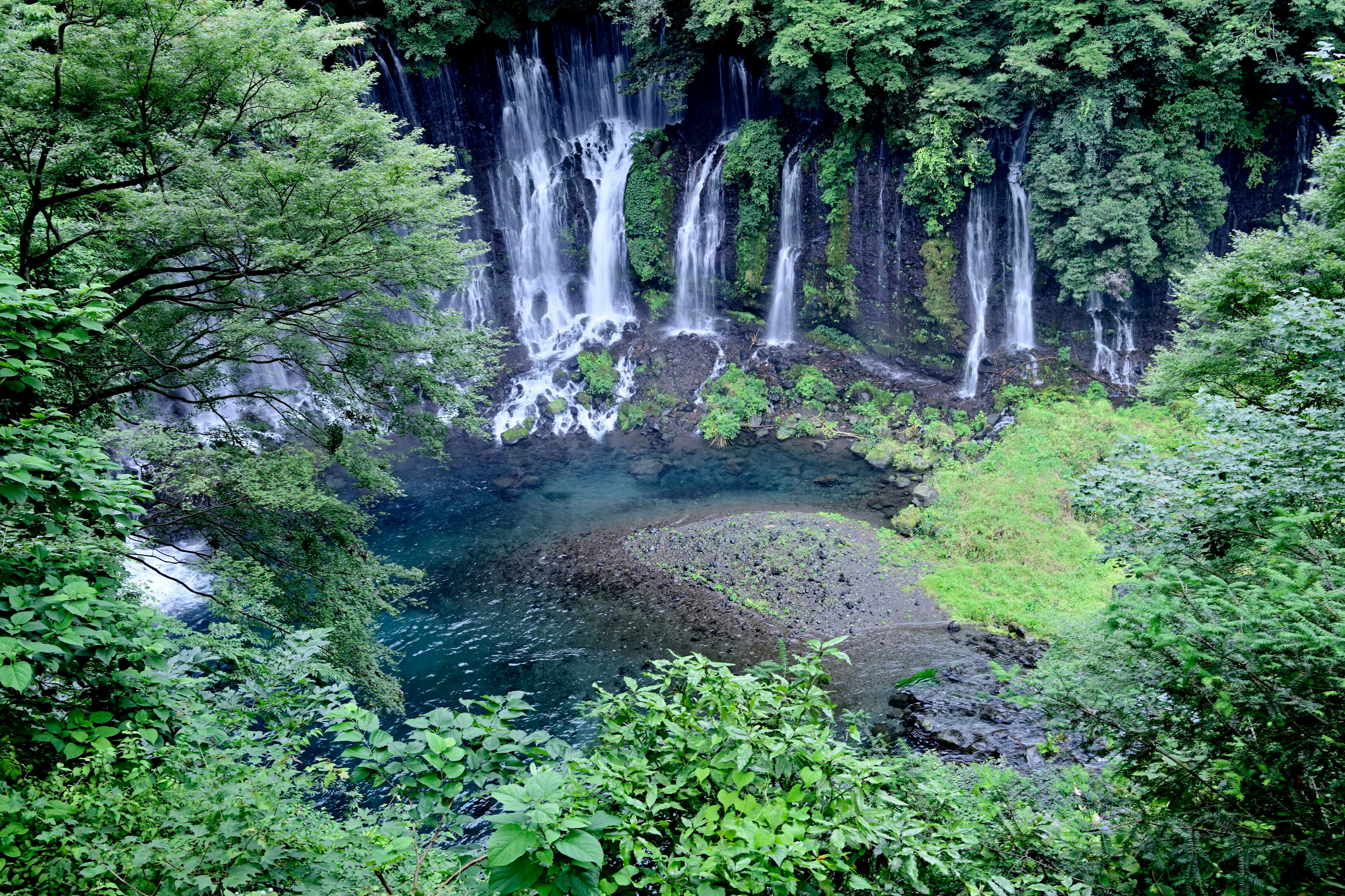 緑の森に囲まれた滝と流れ