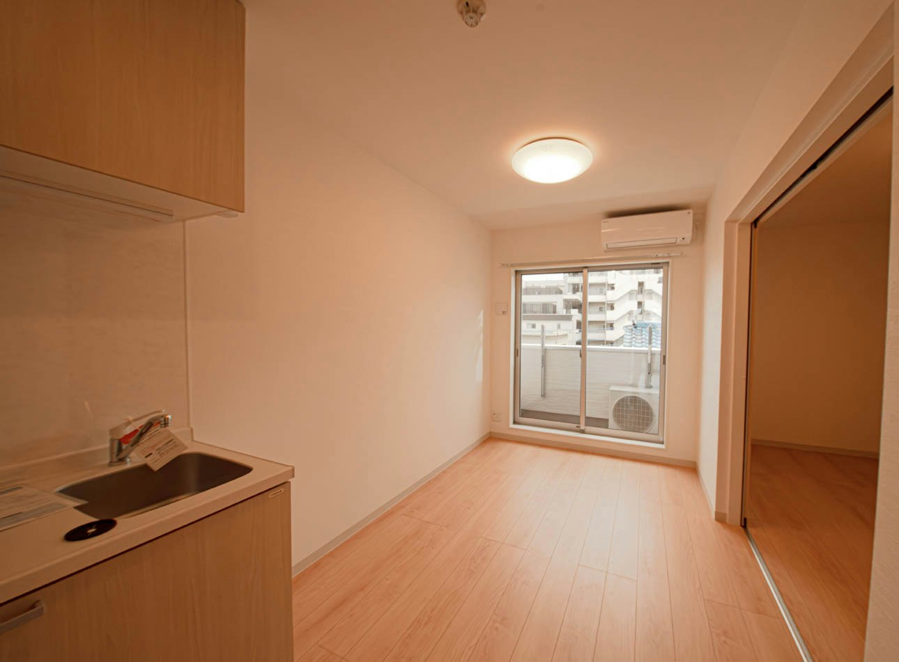 Ruang studio indoor yang terang dengan dapur kecil dan jendela