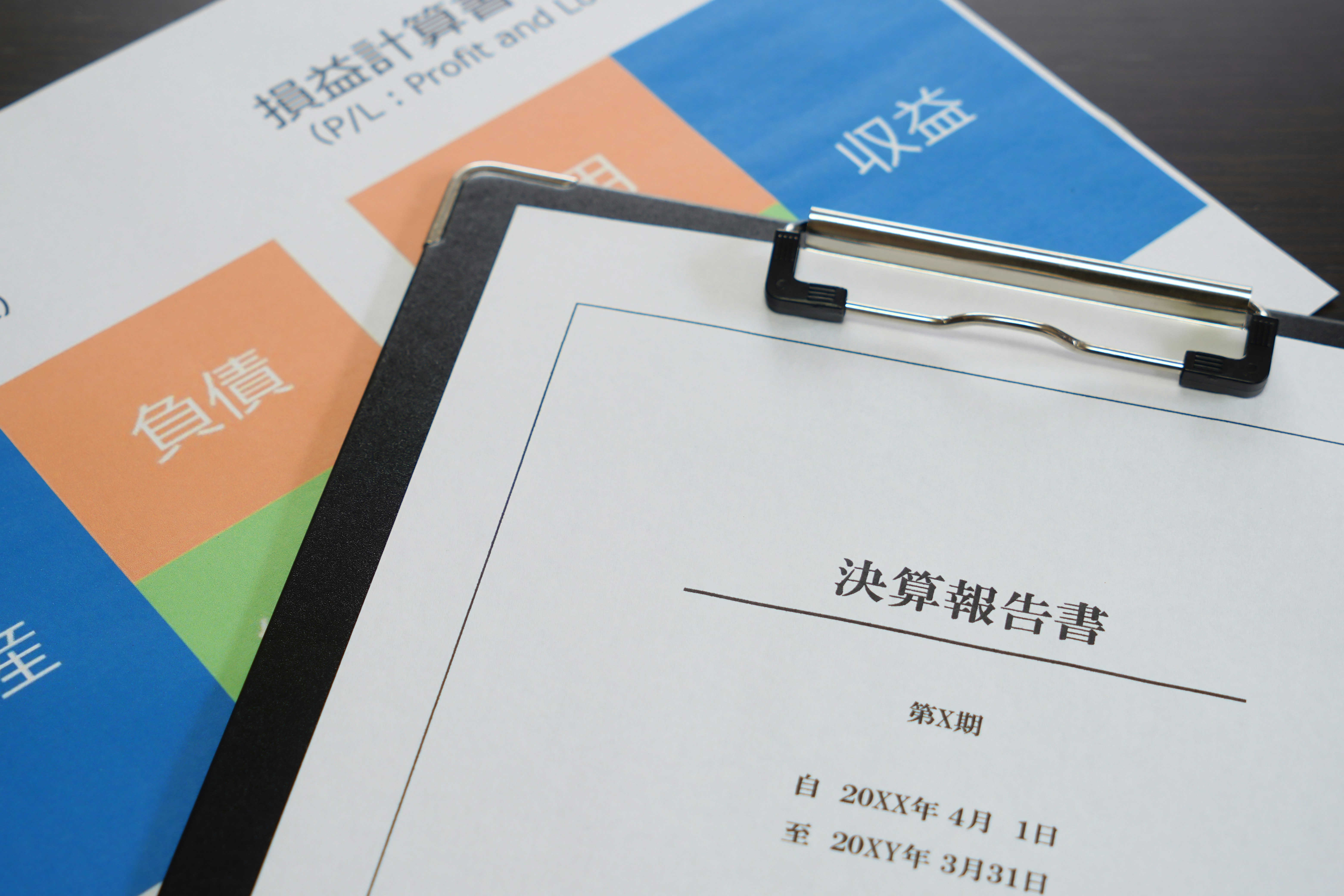 書類ファイルに挟まれた決算報告書