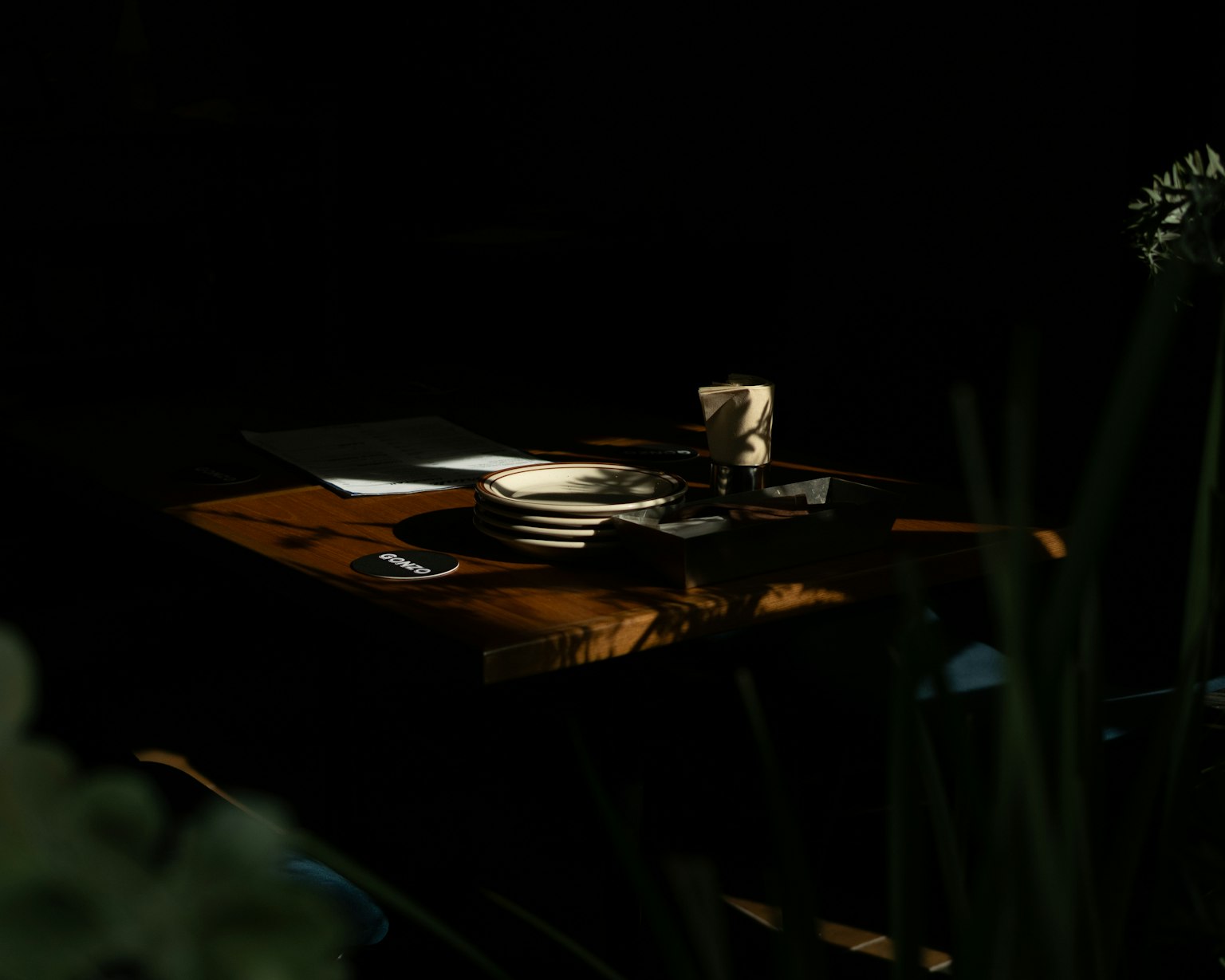 Una mesa en un entorno oscuro con papelería y documentos sobre ella