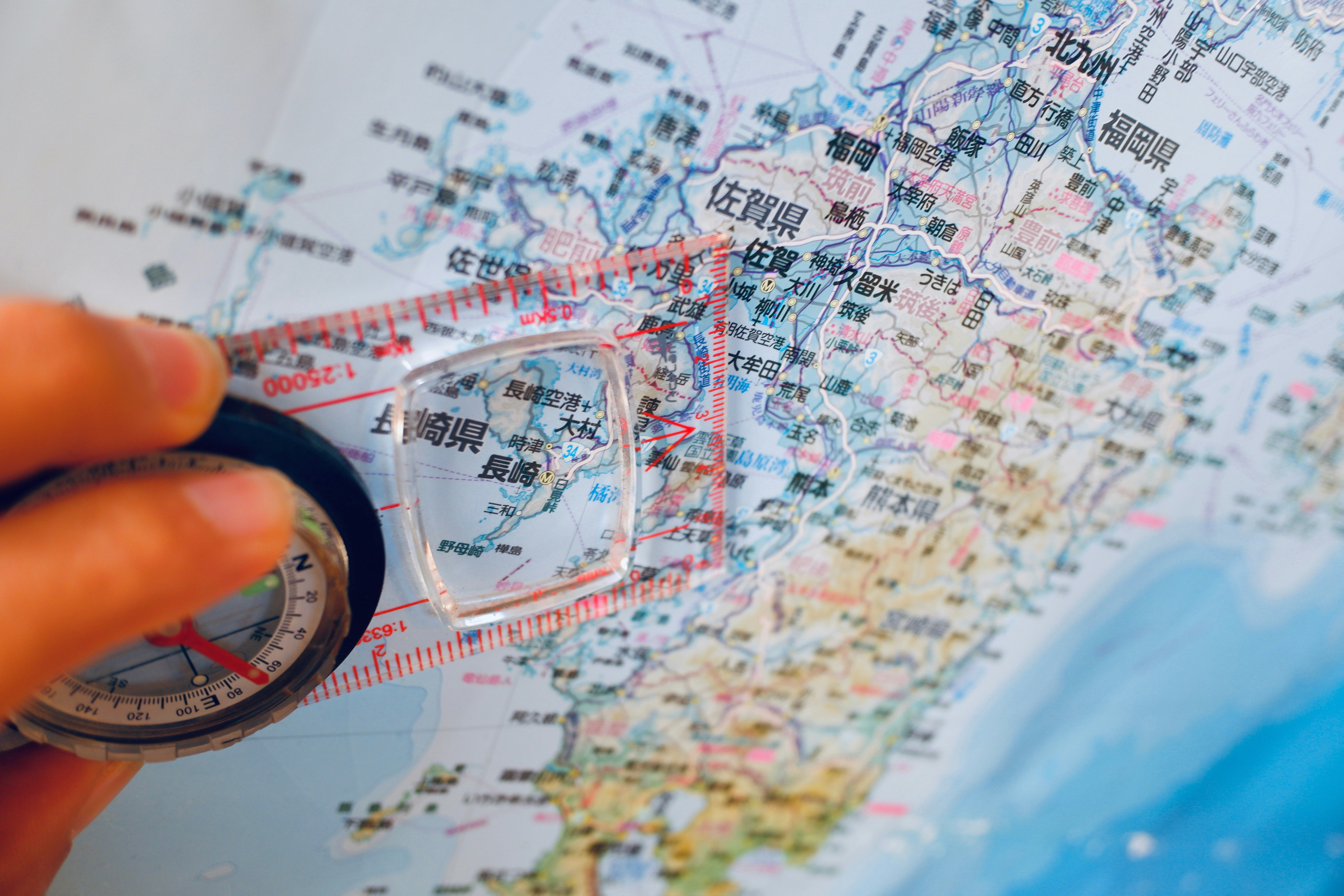 hand holding a compass over a map