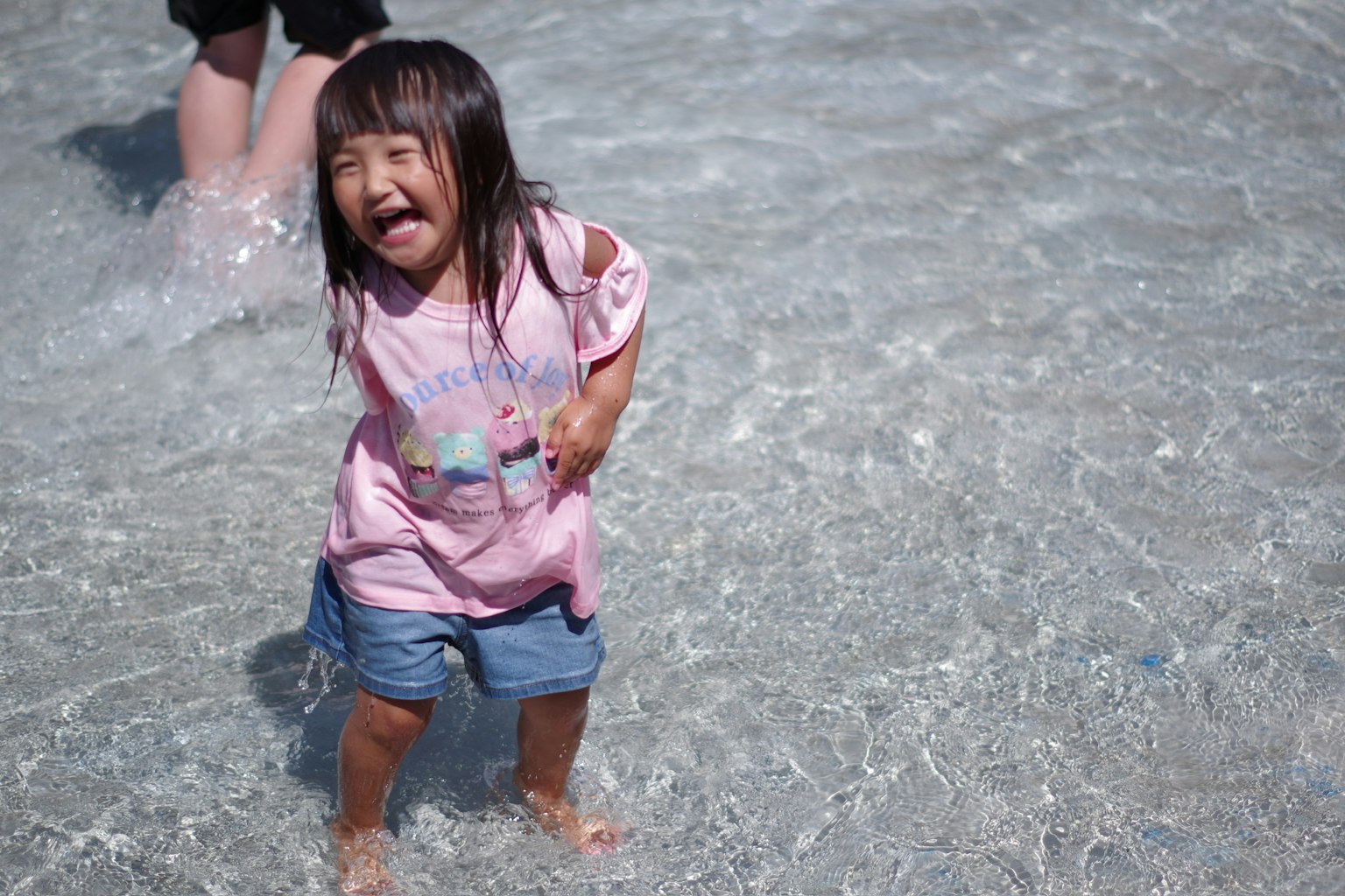 Enfant jouant dans l'eau avec une expression joyeuse
