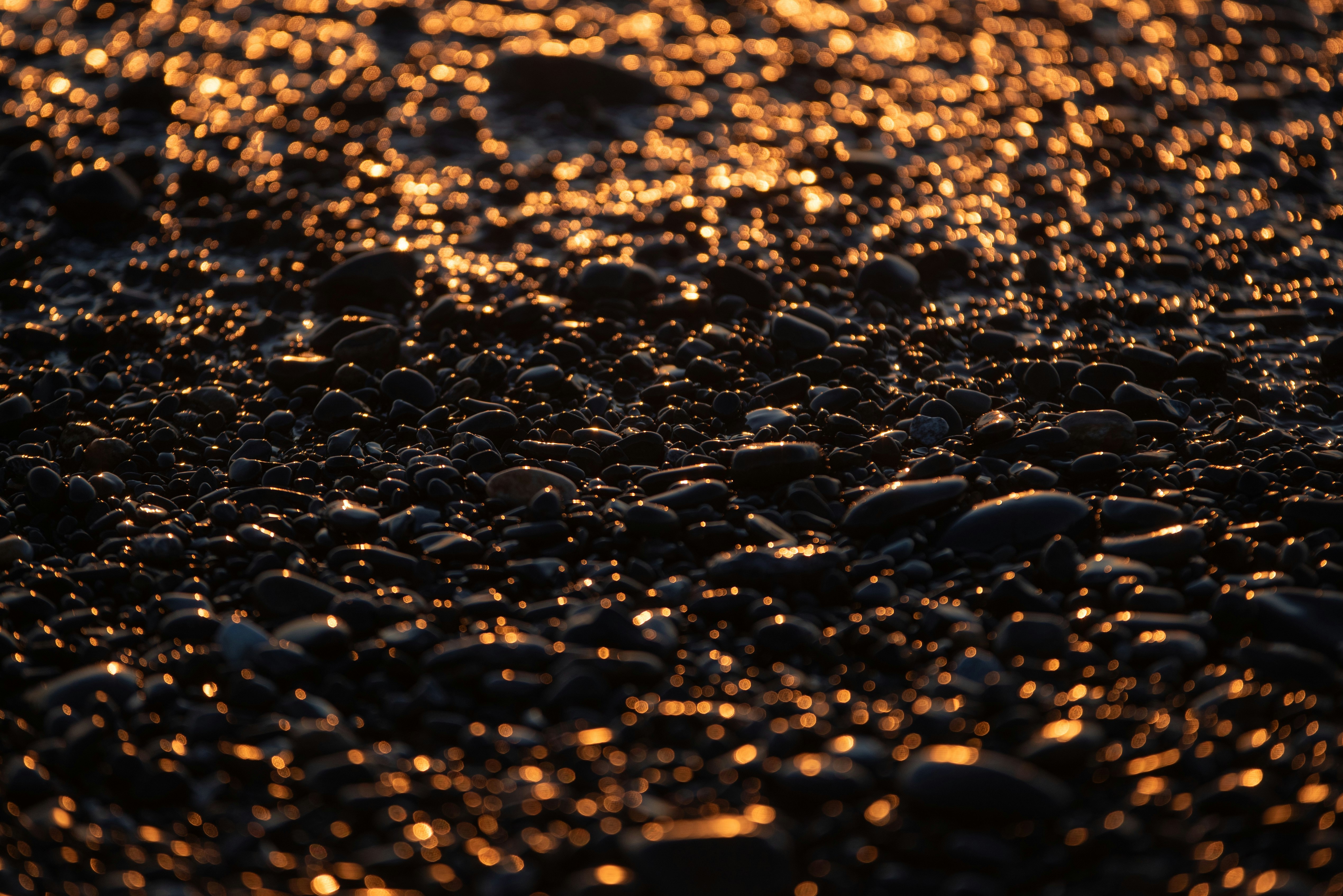 sunlit beach sand with rippling shoreline texture
