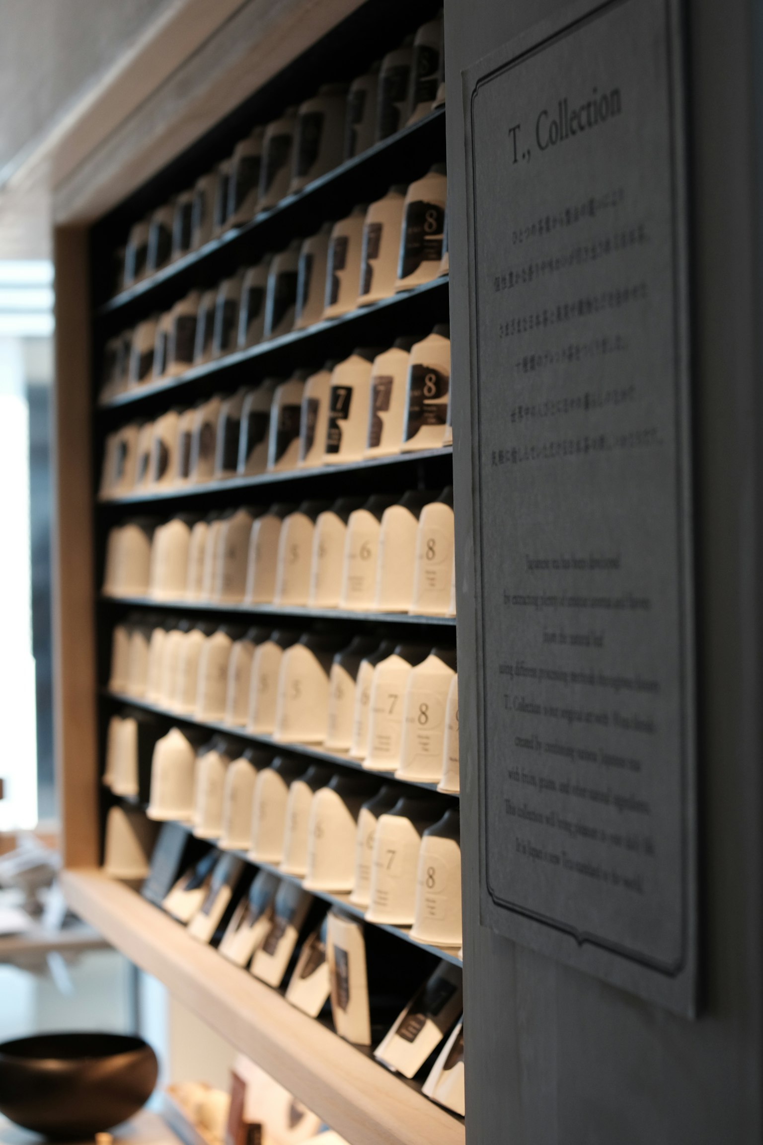 白い陶器の小物が並ぶ棚の一部と説明プレート