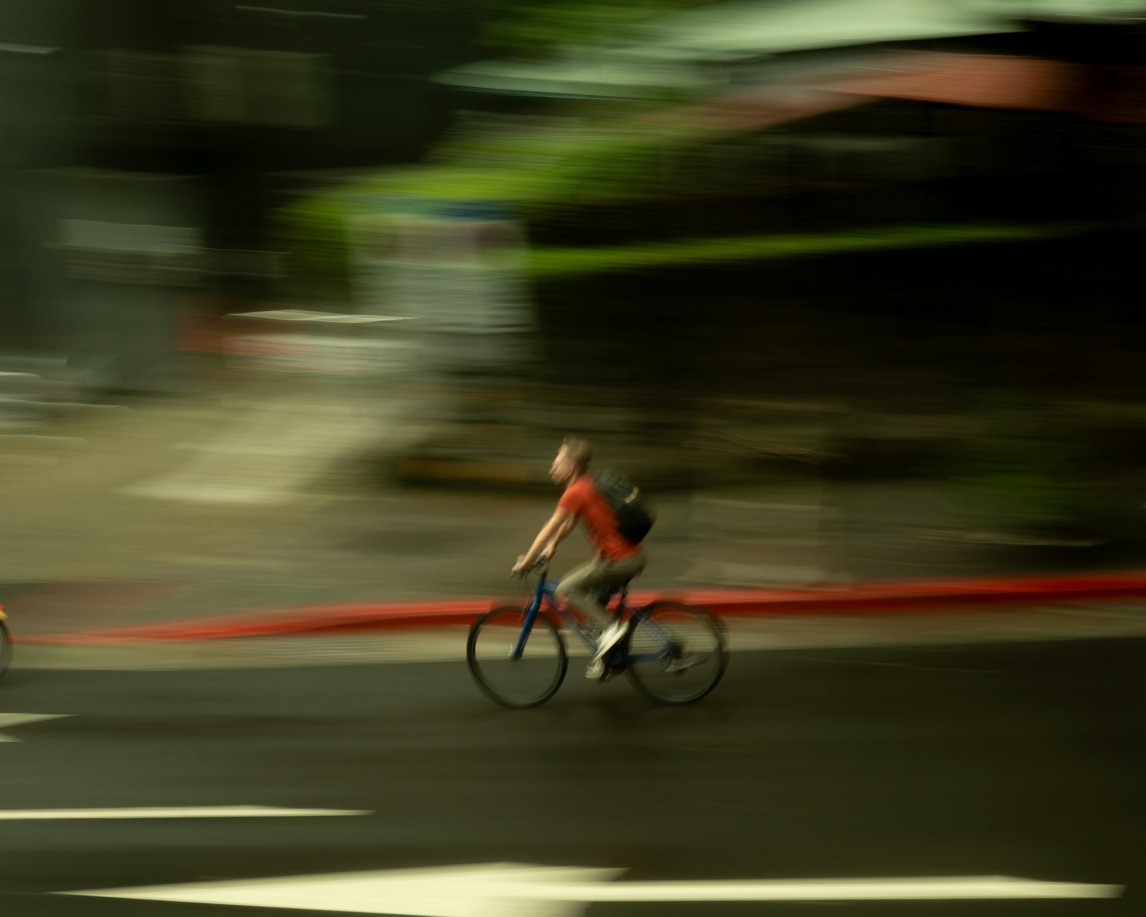 モーションブラーの自転車ライダーが走る街の道路