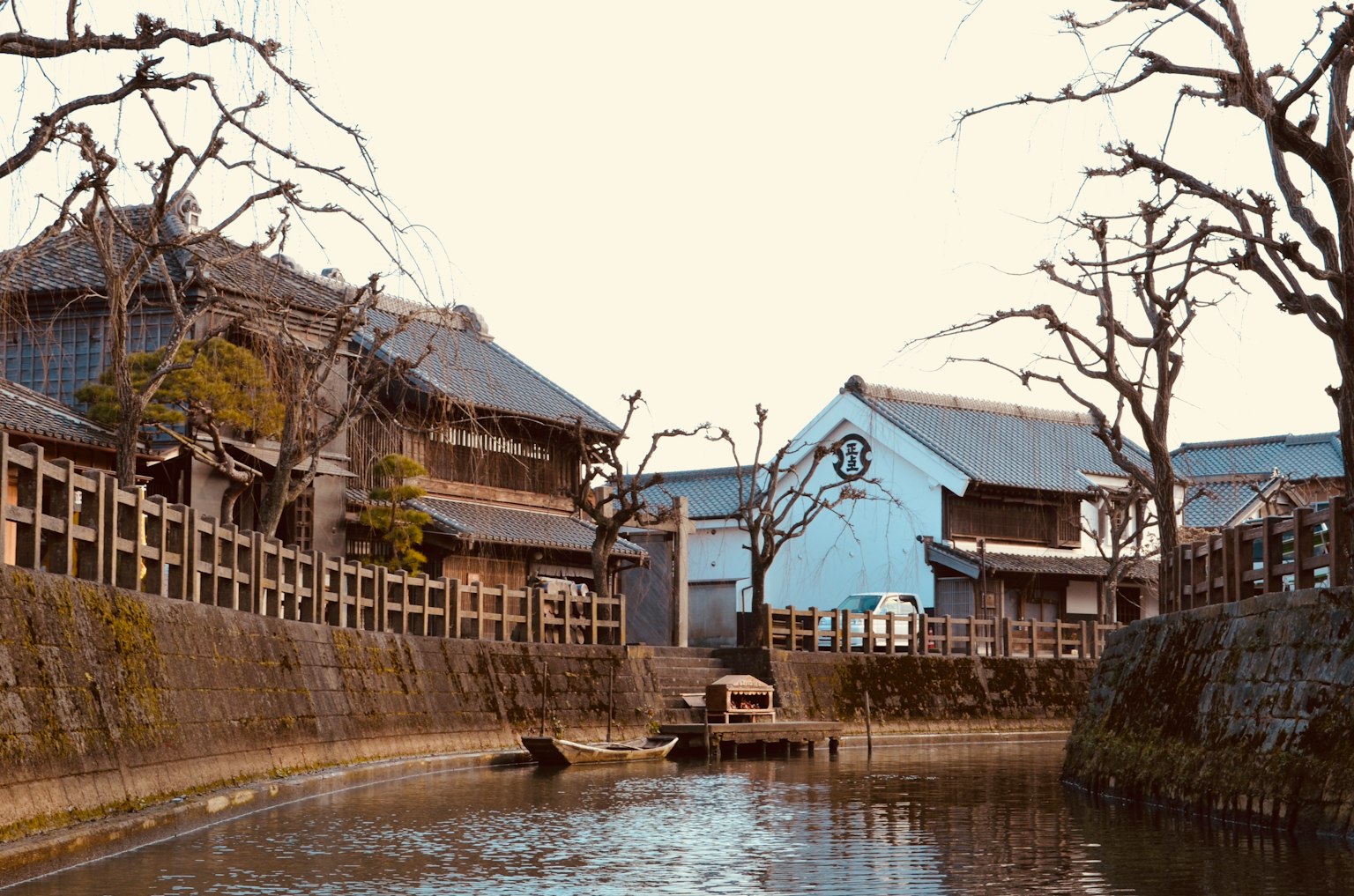 安静的河边景观，古老的木屋和光秃的树木