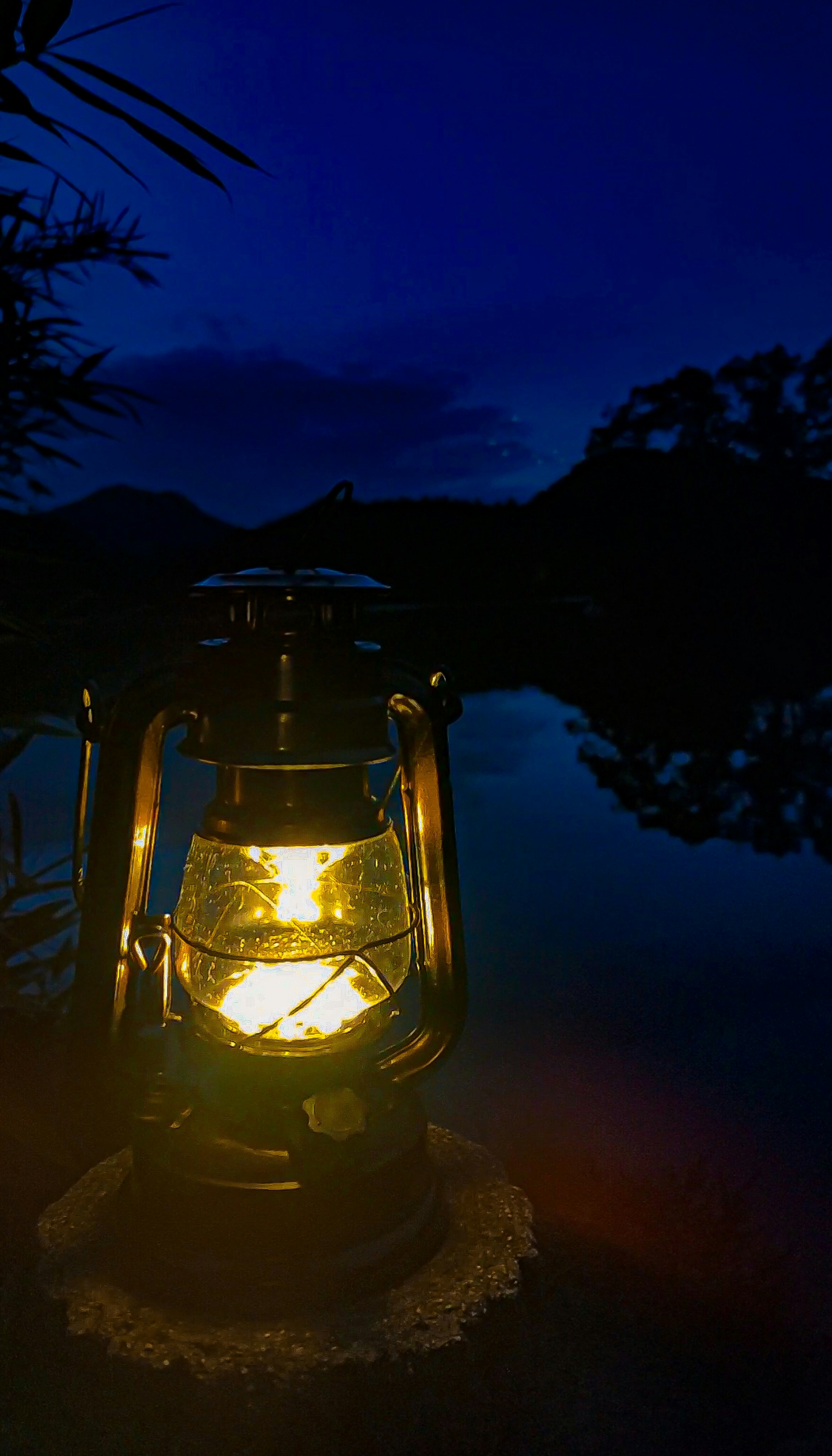 湖畔で灯るランタンの夜のキャンプギア