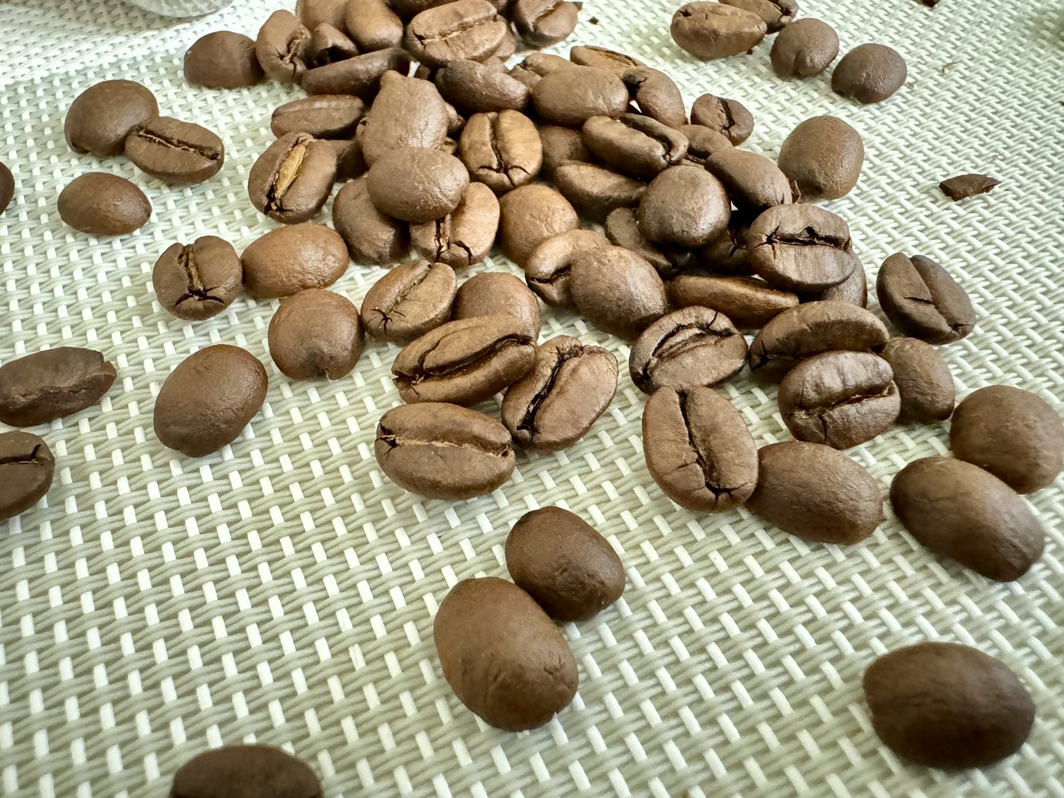 Primer plano de granos de café esparcidos sobre una superficie texturizada