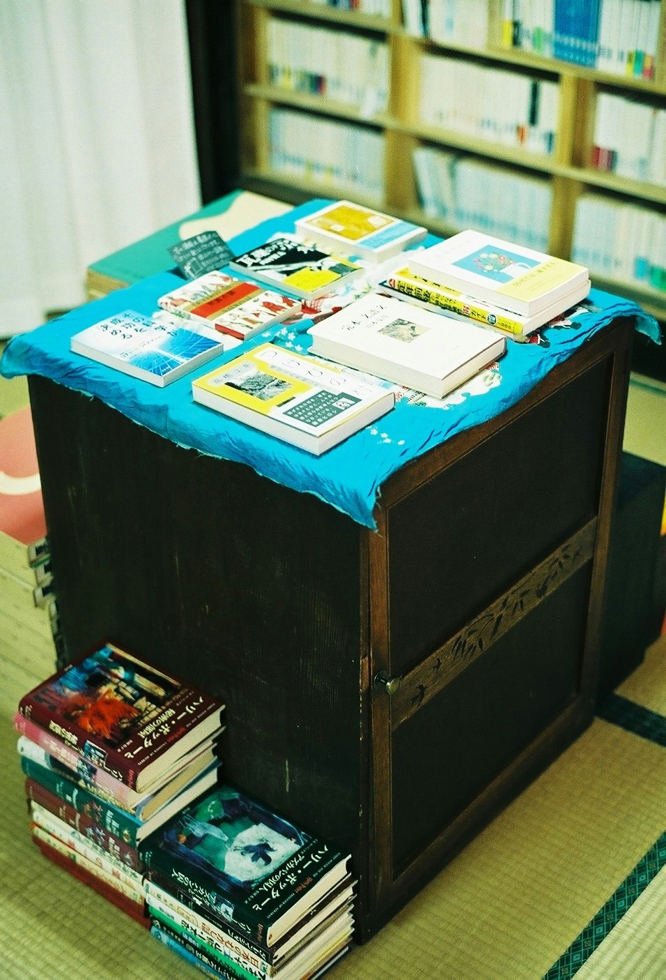 table with books and brochures in front of a library bookshelf