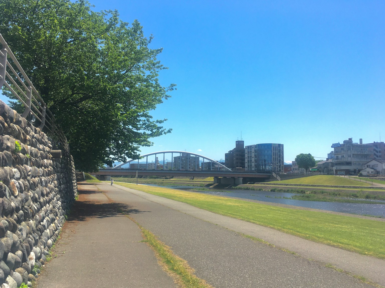 蓝天下河边步道和桥及建筑物