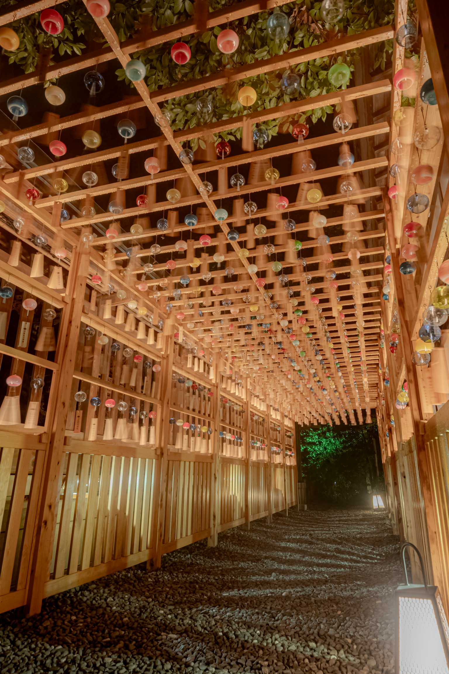 Sentiero luminoso sotto una struttura in legno con decorazioni colorate sopra