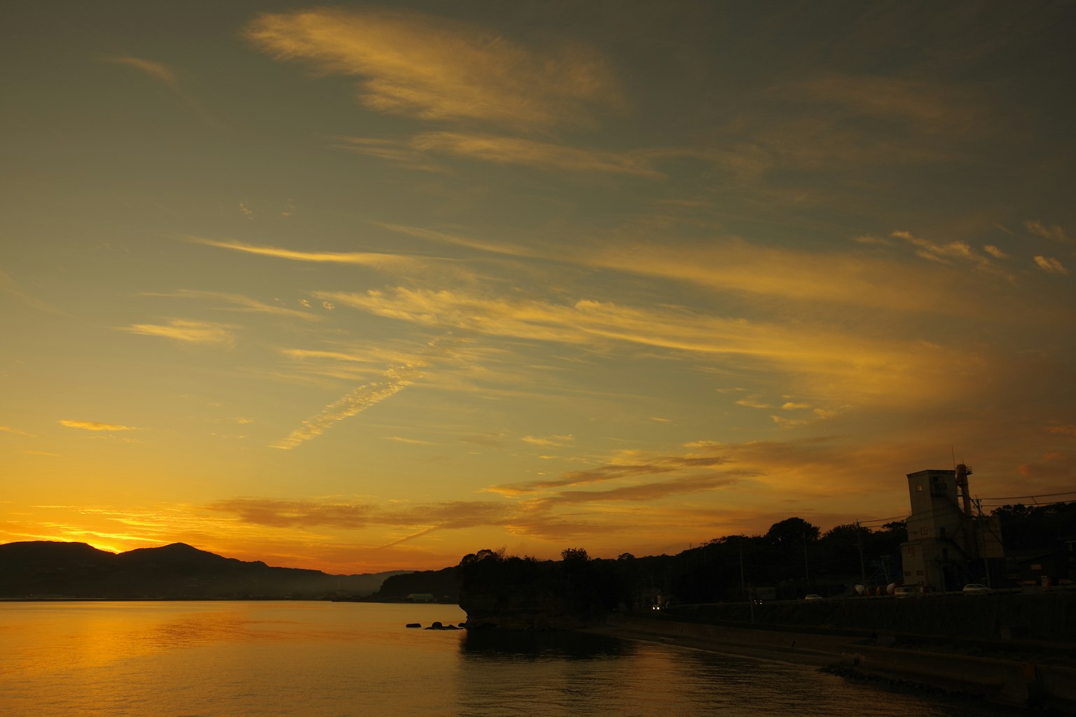 Tramonto su un lago con silhouette di montagne