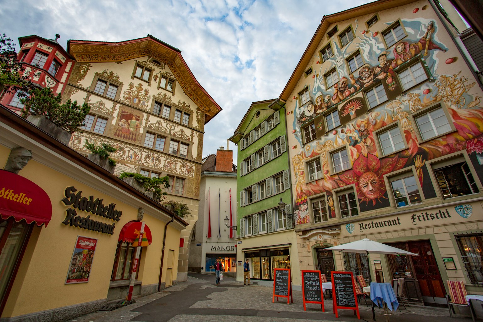 Esquina encantadora con edificios con murales vibrantes y cielo nublado