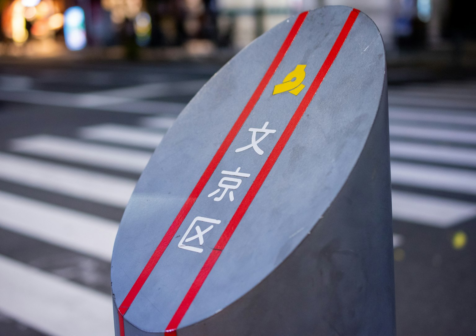 Schild mit der Aufschrift Bunkyo-Viertel in weißen Buchstaben und roten Streifen