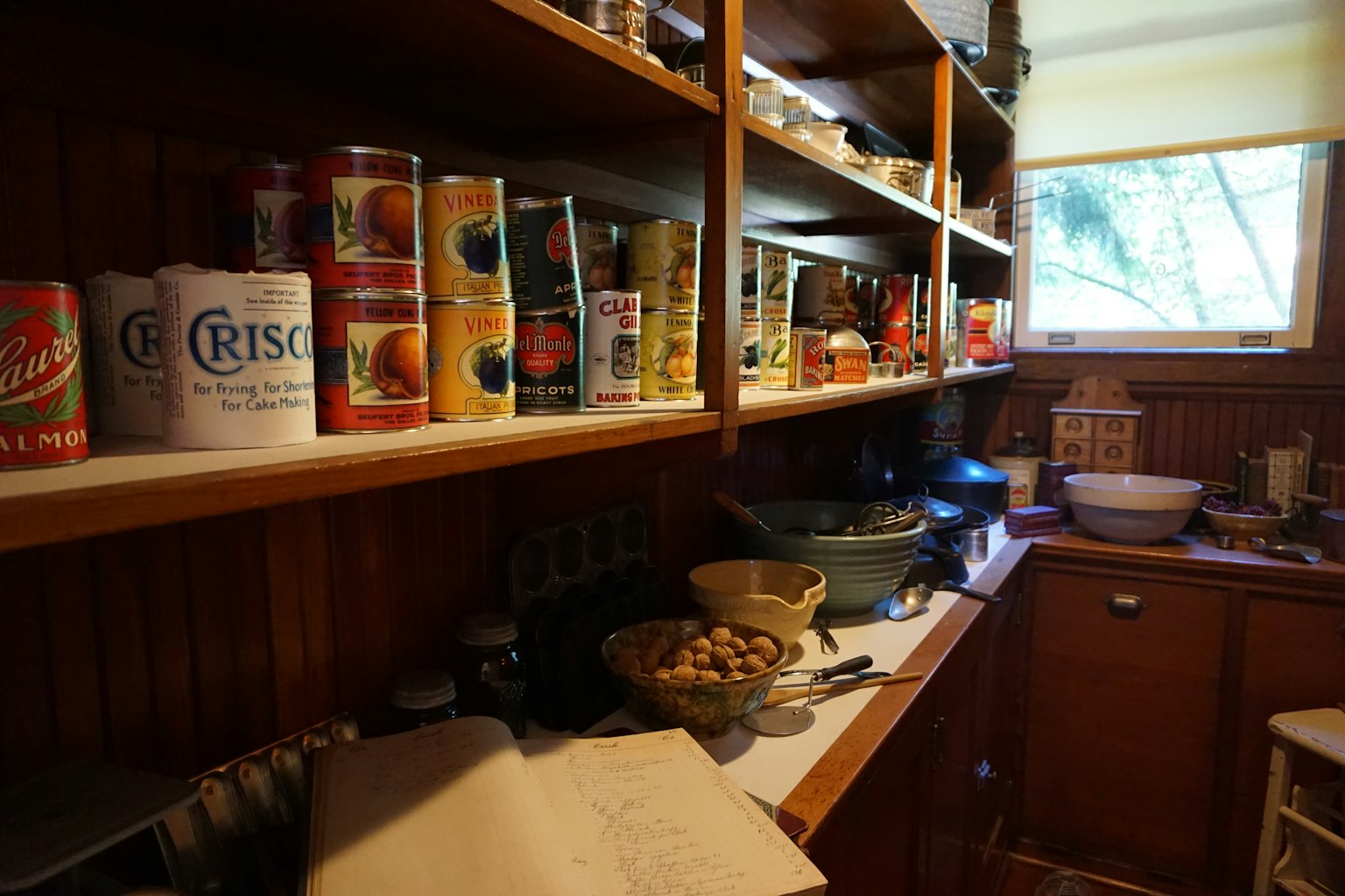 Coin d'une cuisine avec des conserves sur des étagères en bois