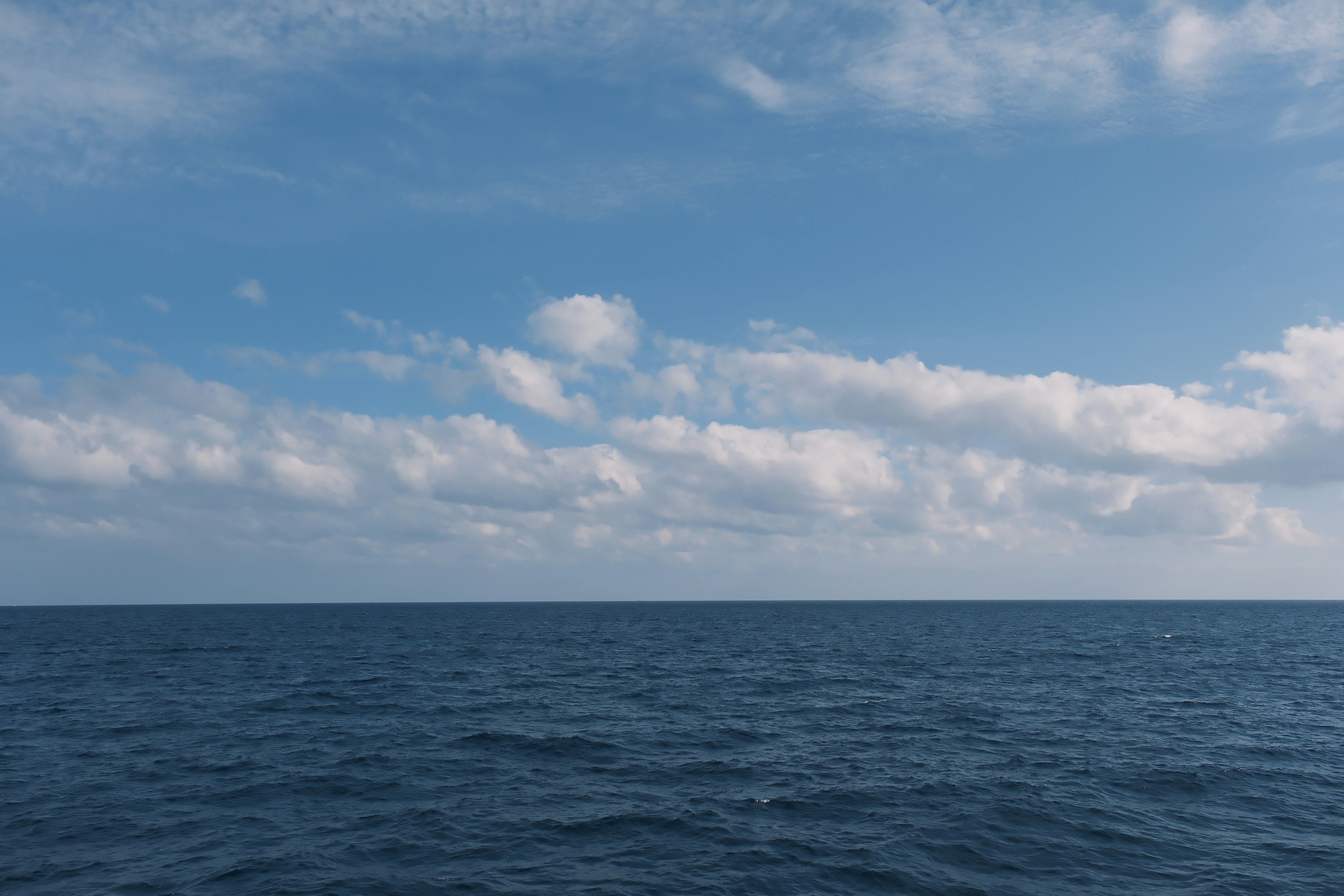 水平線まで広がる穏やかな海と雲の空