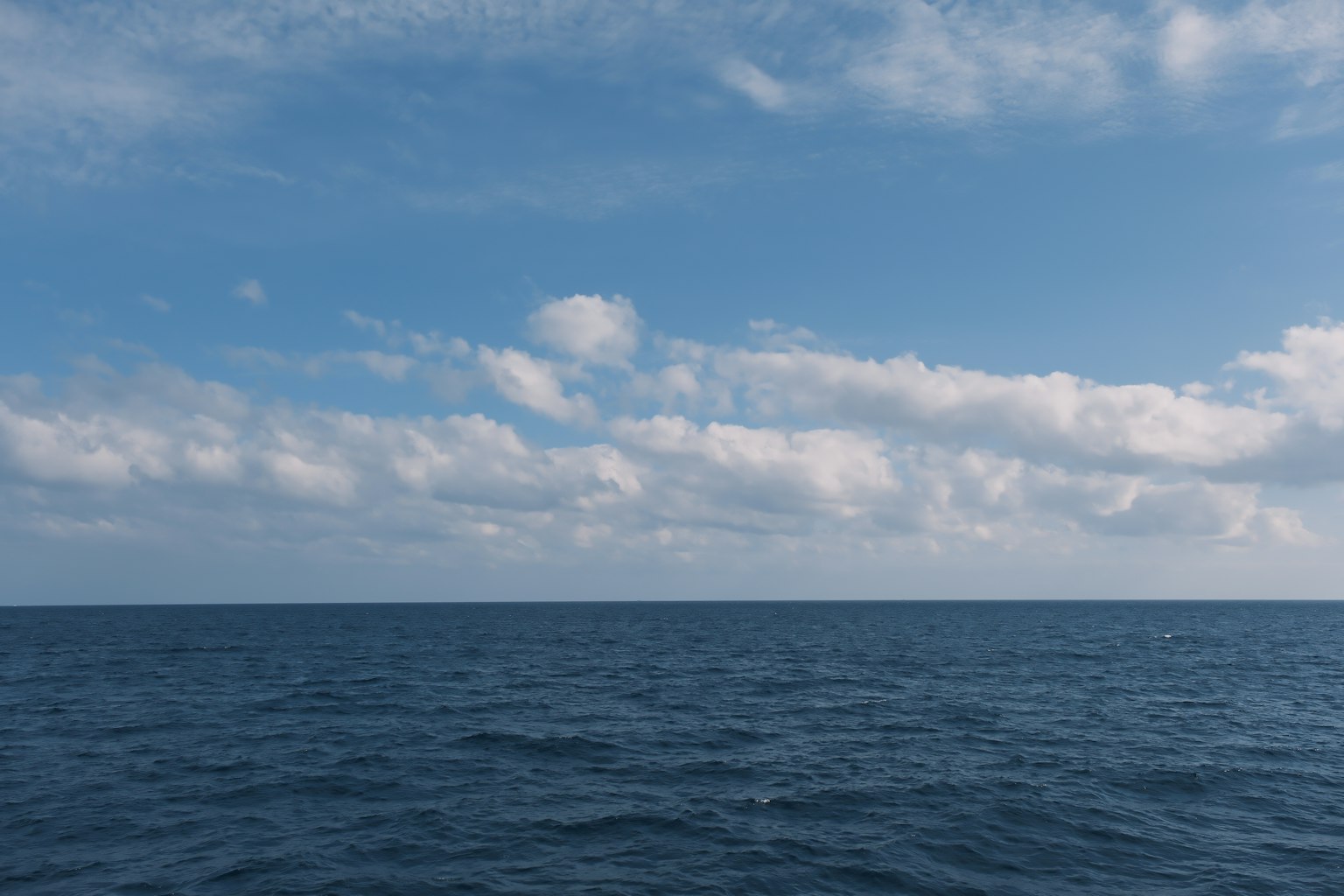 Blue ocean with a clear sky and white clouds