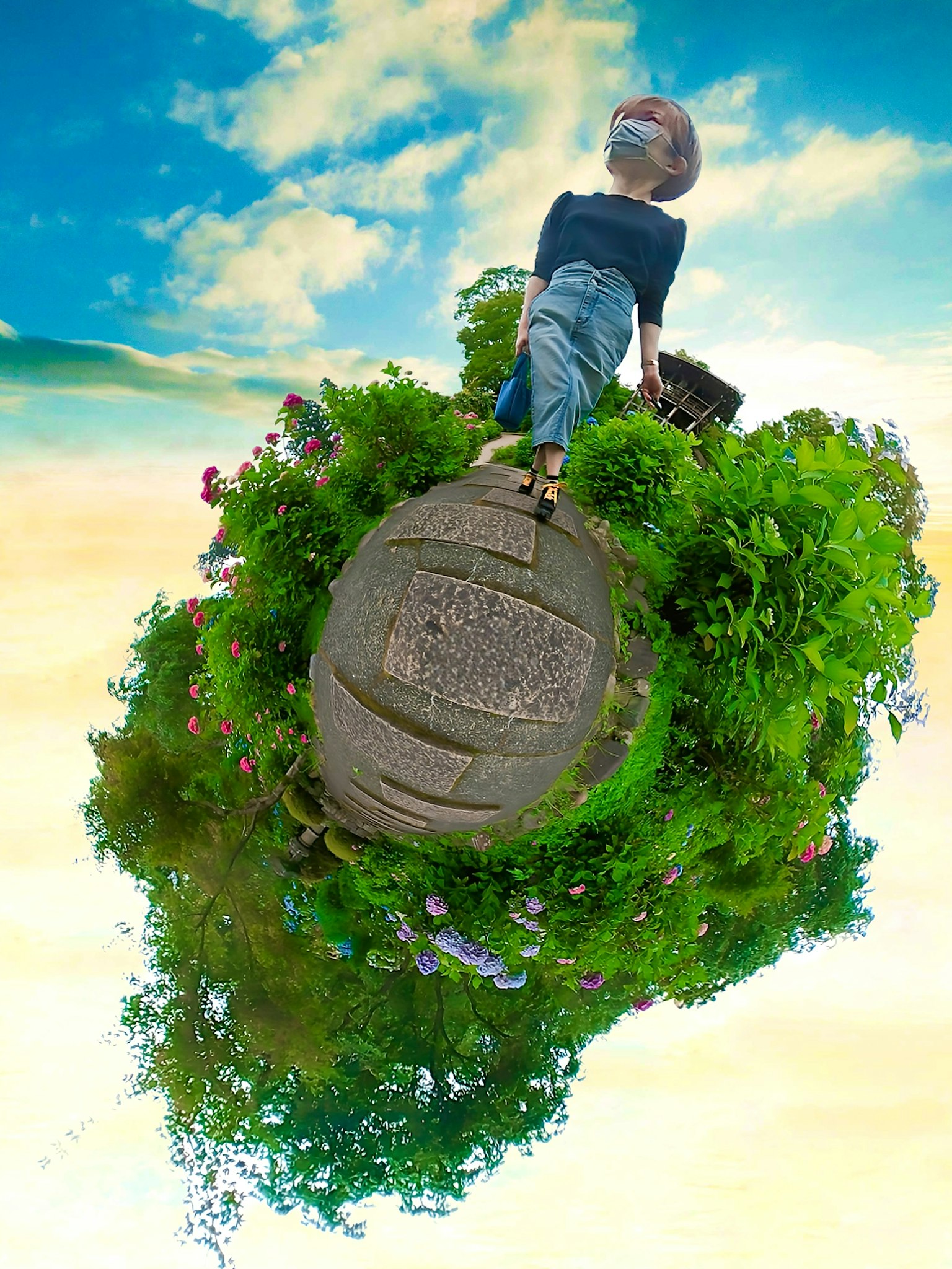 Enfant debout sur une petite planète verte avec ciel bleu